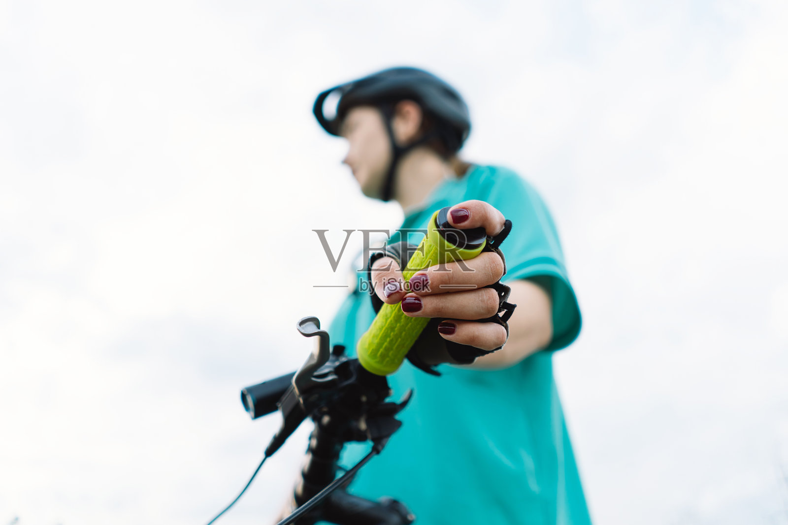 女人的手握着山地车的把手。照片摄影图片