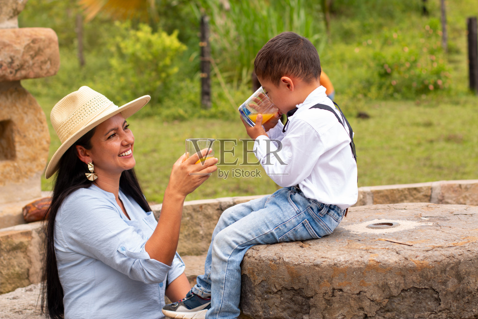生活方式：母亲和孩子在户外喝橙汁照片摄影图片