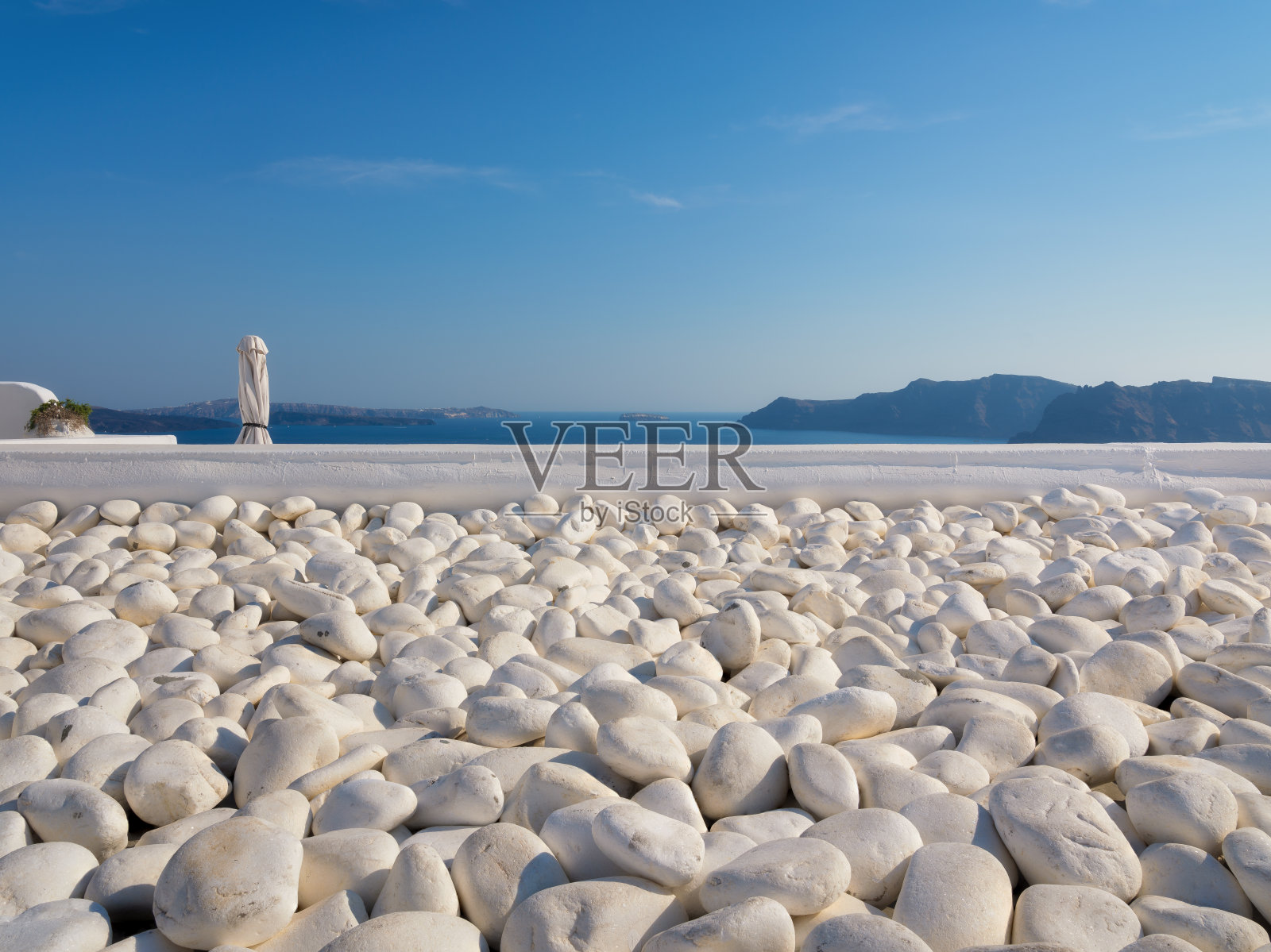 白色的圆卵石在蓝天的背景下。自然材料作为背景。冥想和放松的地方。照片摄影图片
