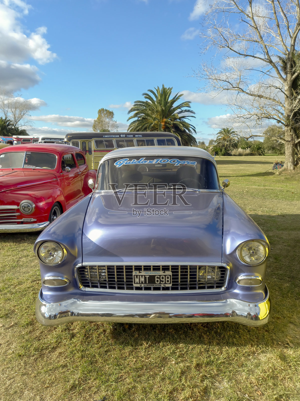 在一场经典车展上，一辆1955年老款雪佛兰贝尔艾尔双门轿车停在公园草坪上照片摄影图片