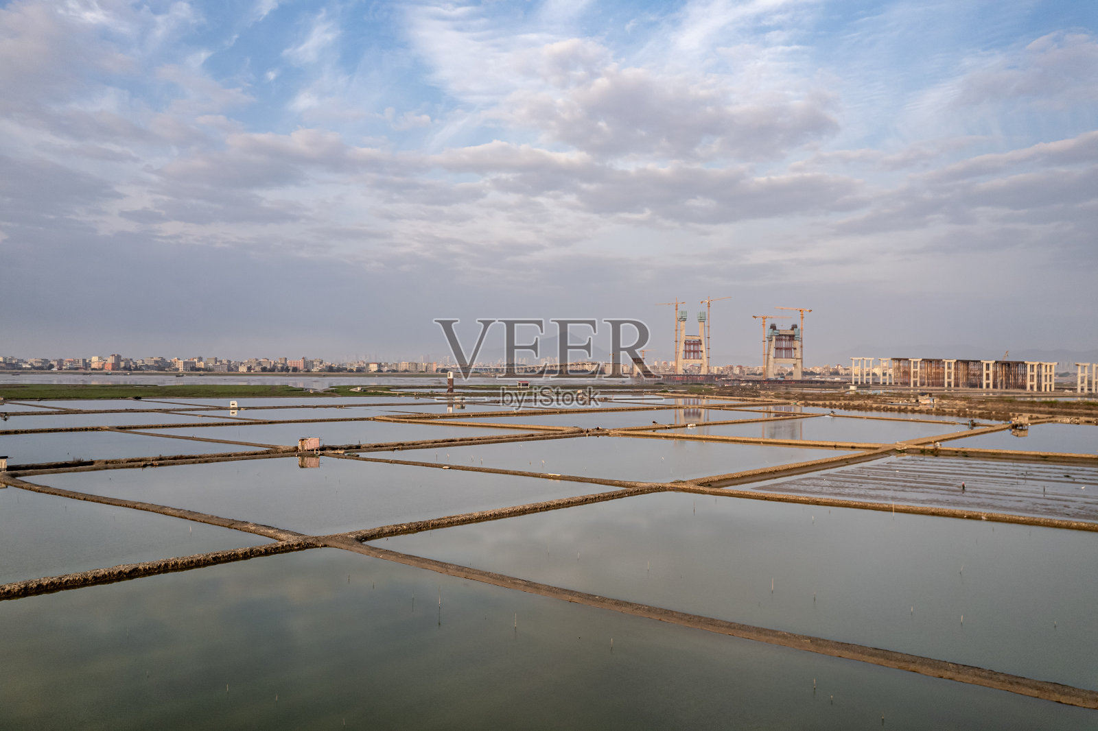 在多云天的黎明鸟瞰泥滩上的养鱼塘照片摄影图片