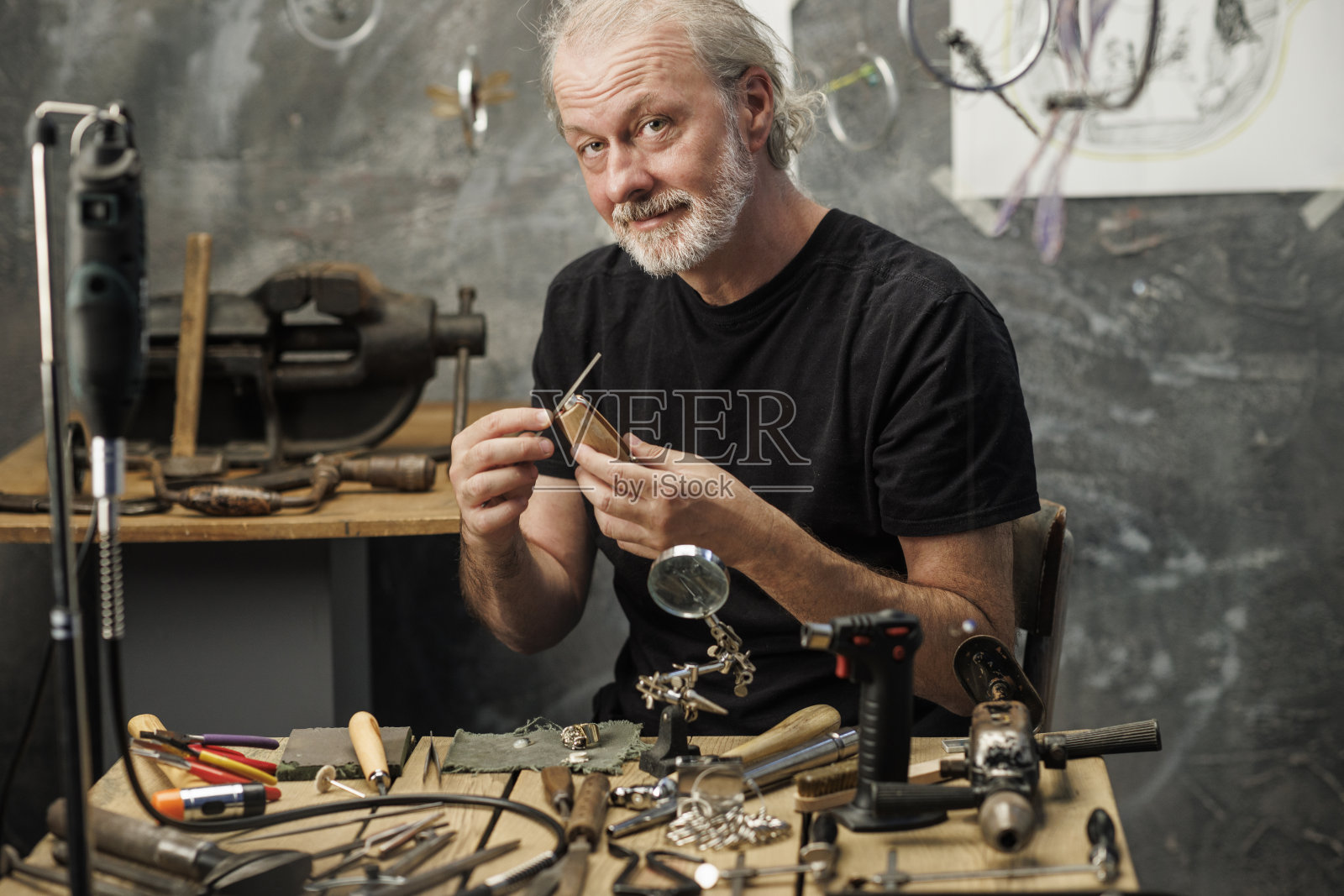 男子珠宝商，生产手工制作的戒指，使用金属锉刀。珠宝商工艺工作坊照片摄影图片