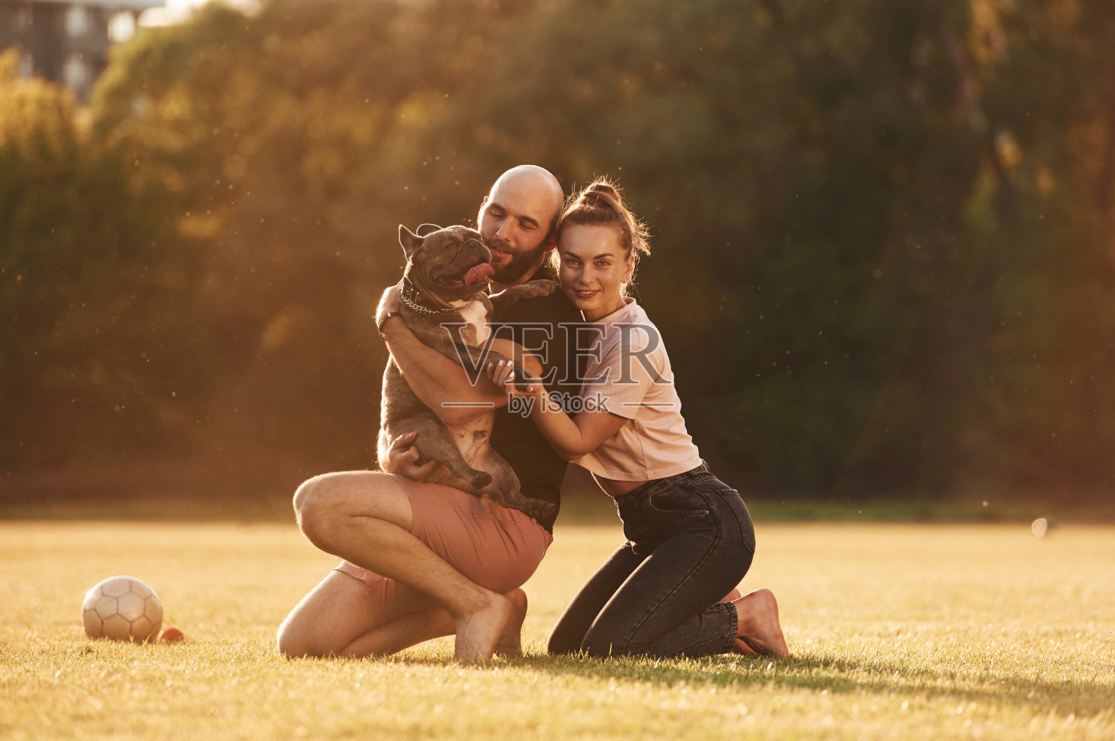 积极的面部表情，休息。一男一女带着狗在操场上照片摄影图片