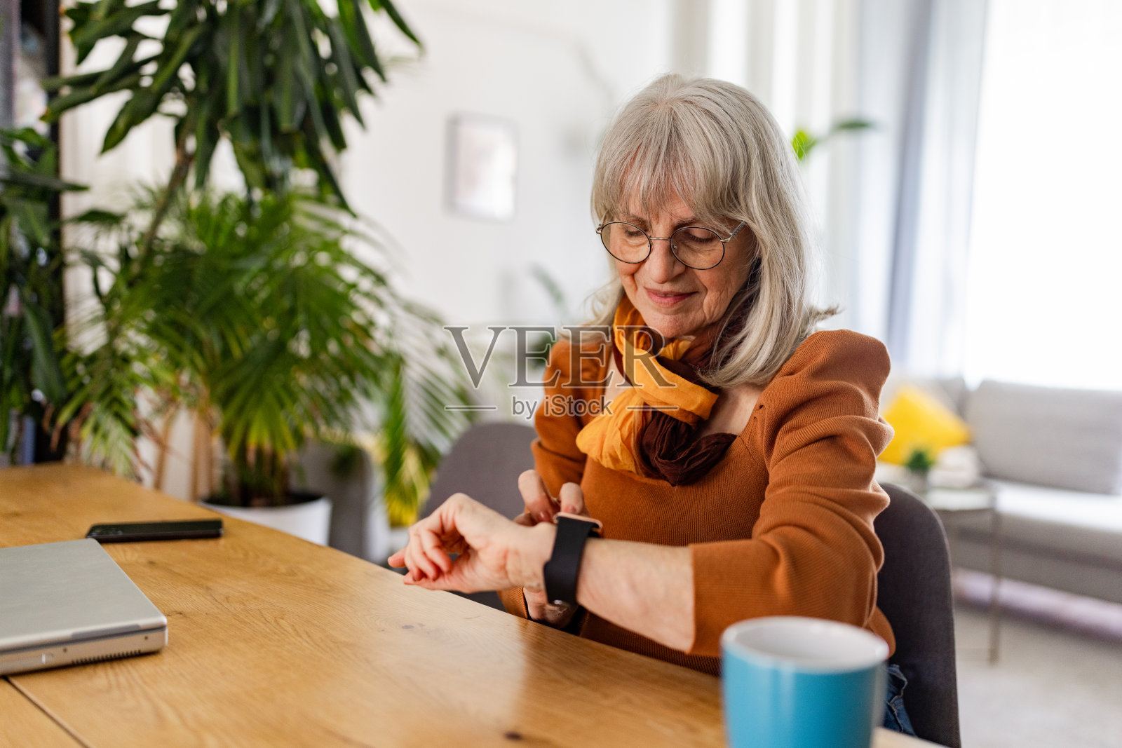老年女性用智能手表拥抱科技照片摄影图片