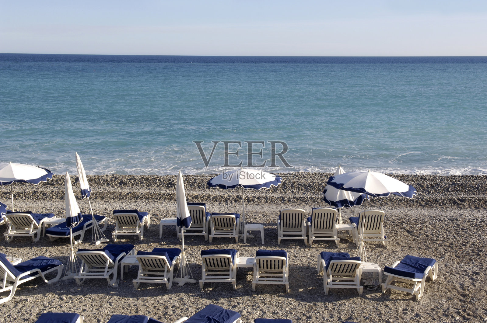 法国尼斯海滩上的遮阳伞和躺椅照片摄影图片