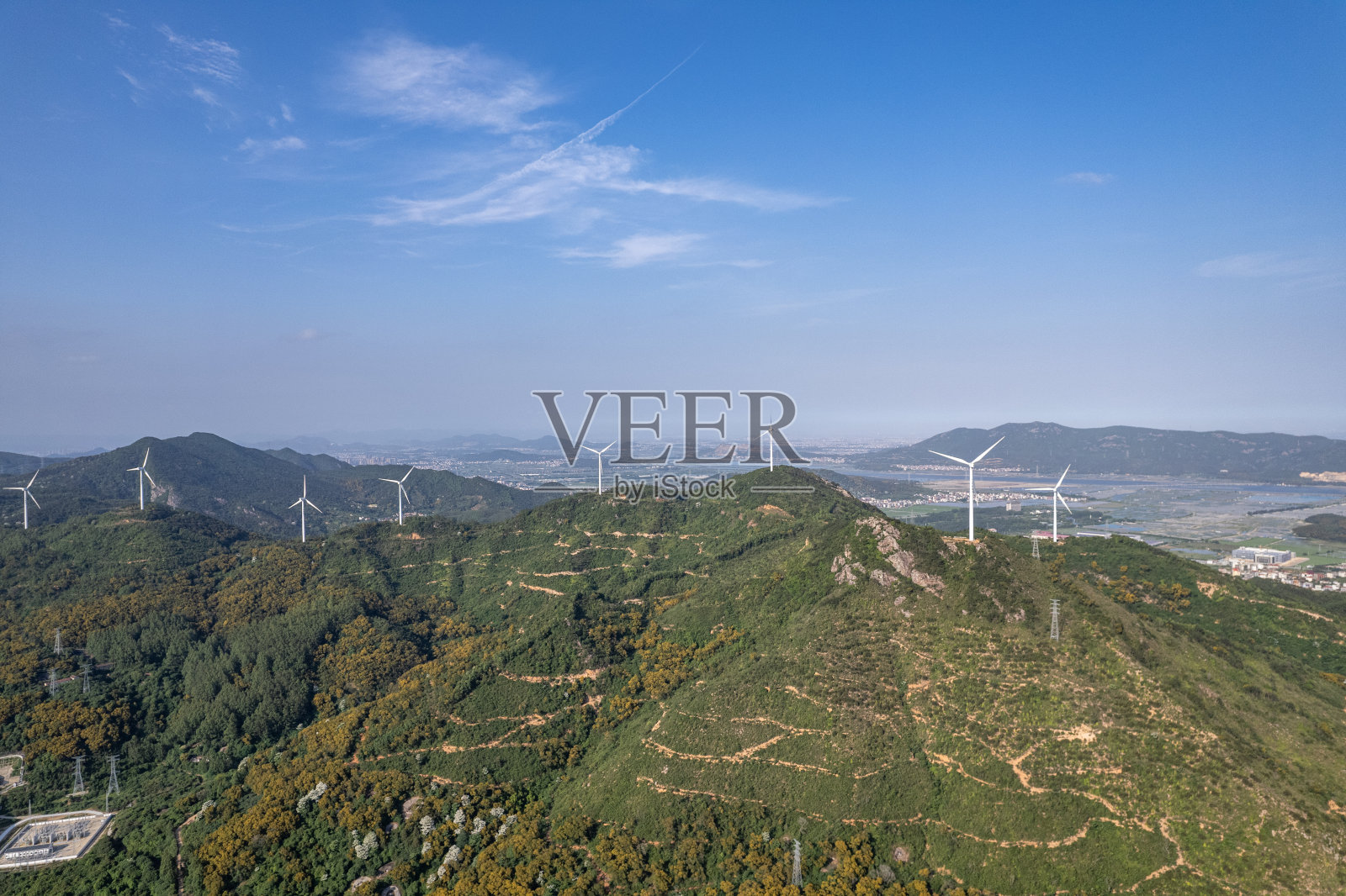 山脚下的乡村房屋和山上的风力涡轮机鸟瞰图照片摄影图片