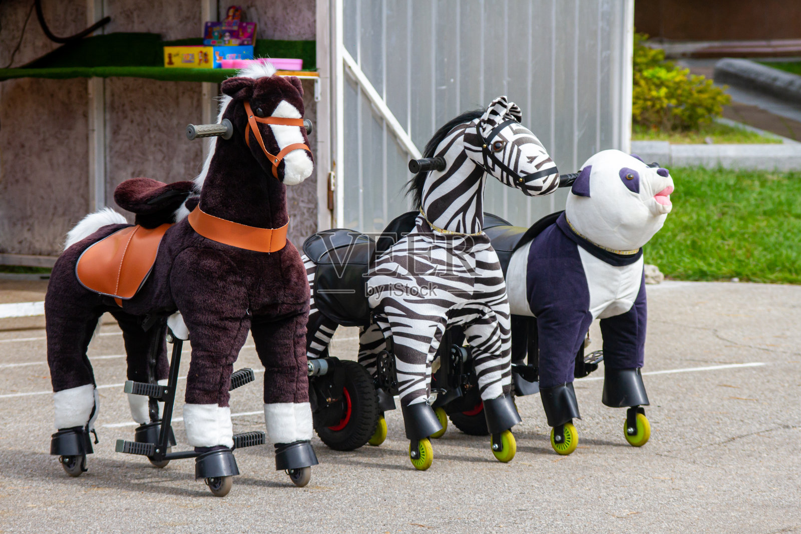 孩子们在夏季公园骑着马玩的游乐设施照片摄影图片