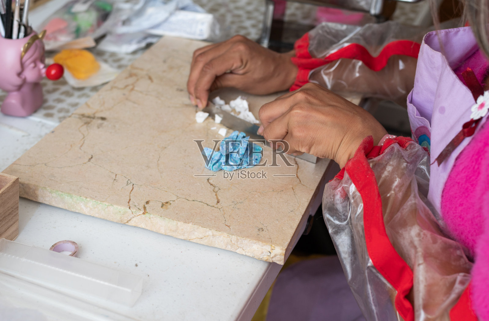 女工匠用抹刀切割蓝色聚合物粘土照片摄影图片