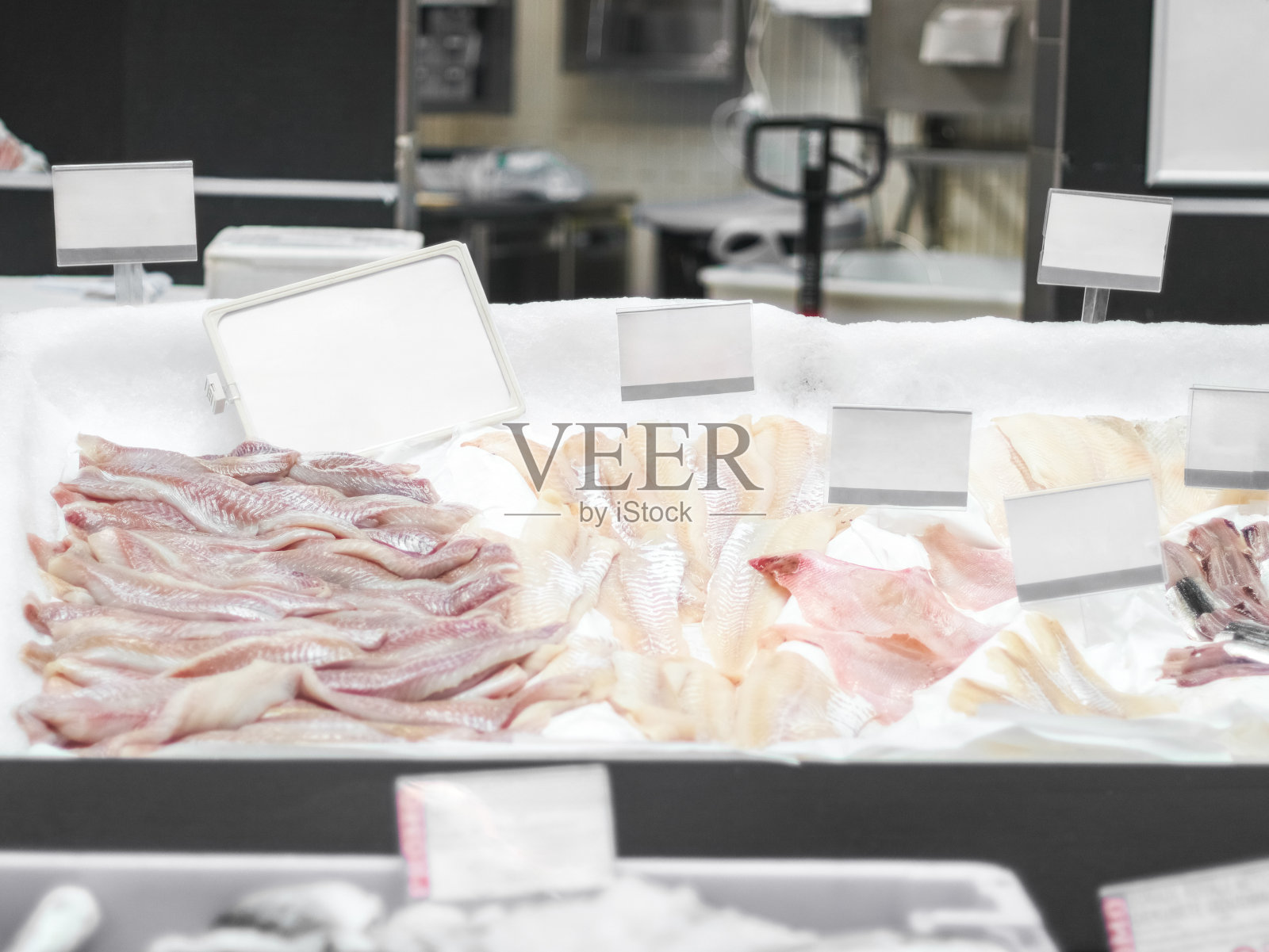 商店柜台上各种各样的白鱼。照片摄影图片