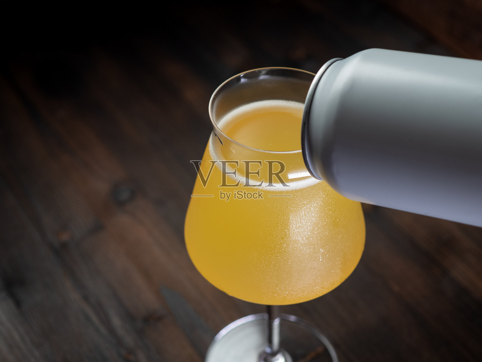 工艺苹果酒。香蕉苹果酒装在时髦的玻璃杯里。照片摄影图片