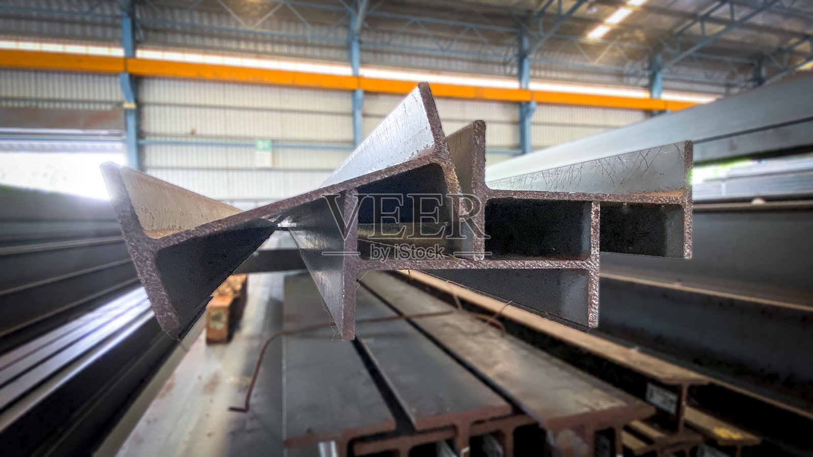 金属制品仓库的金属型材梁。工字钢，仓库内的法兰梁，放置在钢架上的钢梁，钢结构，结构钢照片摄影图片