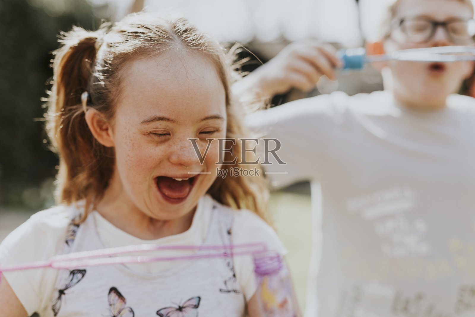 快乐的兄妹在后院吹泡泡玩耍照片摄影图片