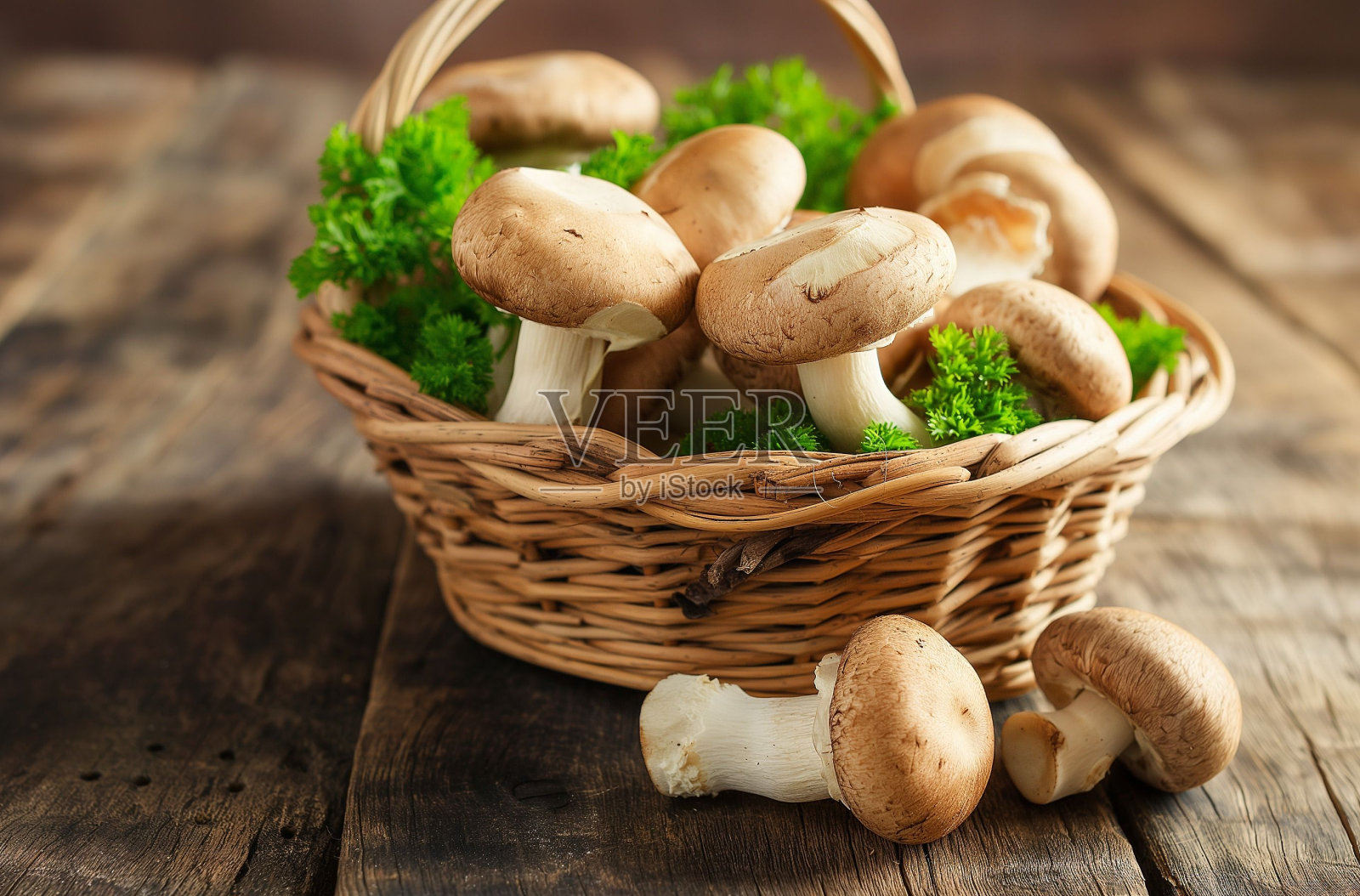 柳条篮子里装满了新鲜的蘑菇和欧芹，放在一张质朴的木桌上照片摄影图片