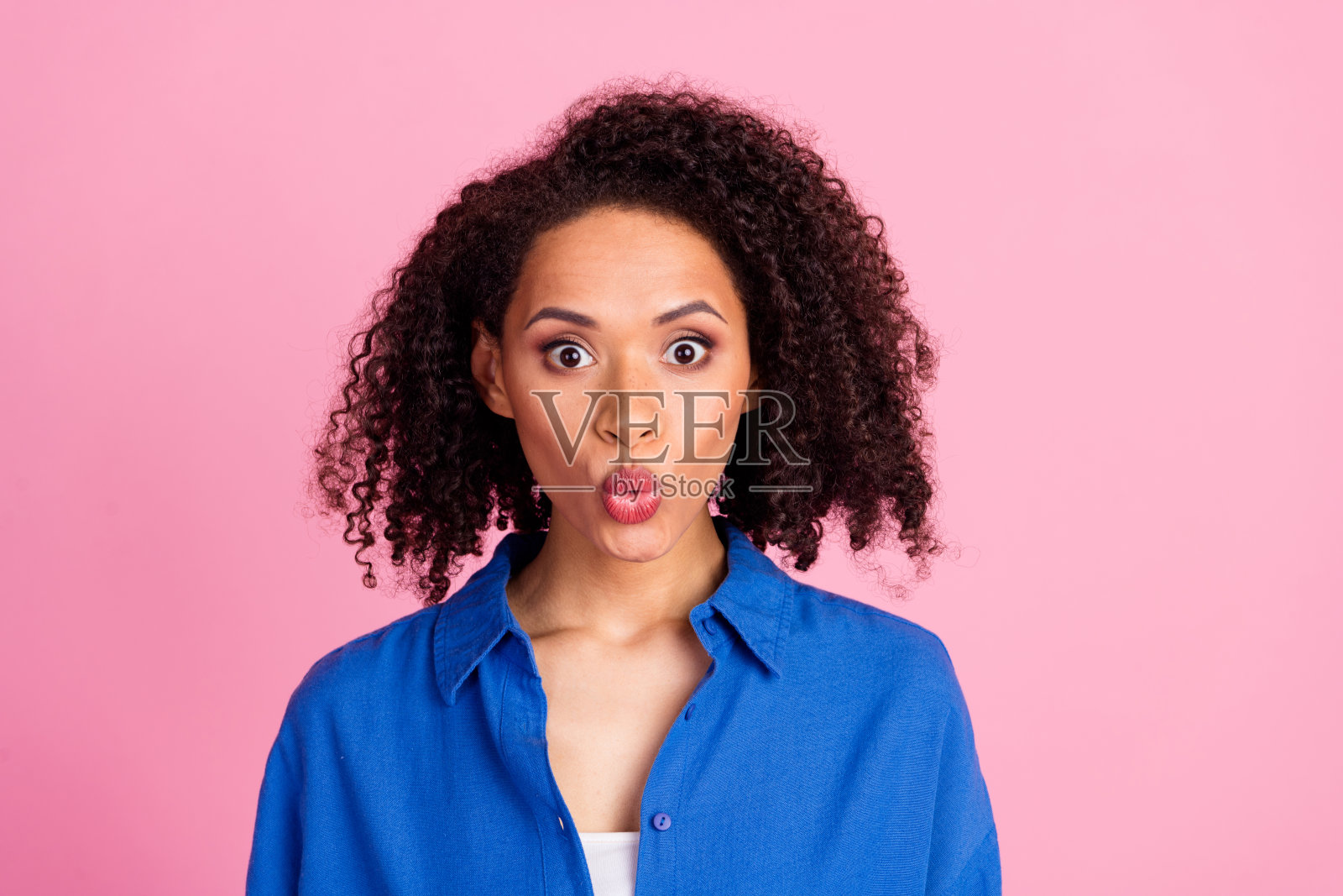 令人印象深刻的可爱可爱的女人穿着蓝色时尚的衣服的照片，在粉红色的背景上孤立的新闻销售照片摄影图片