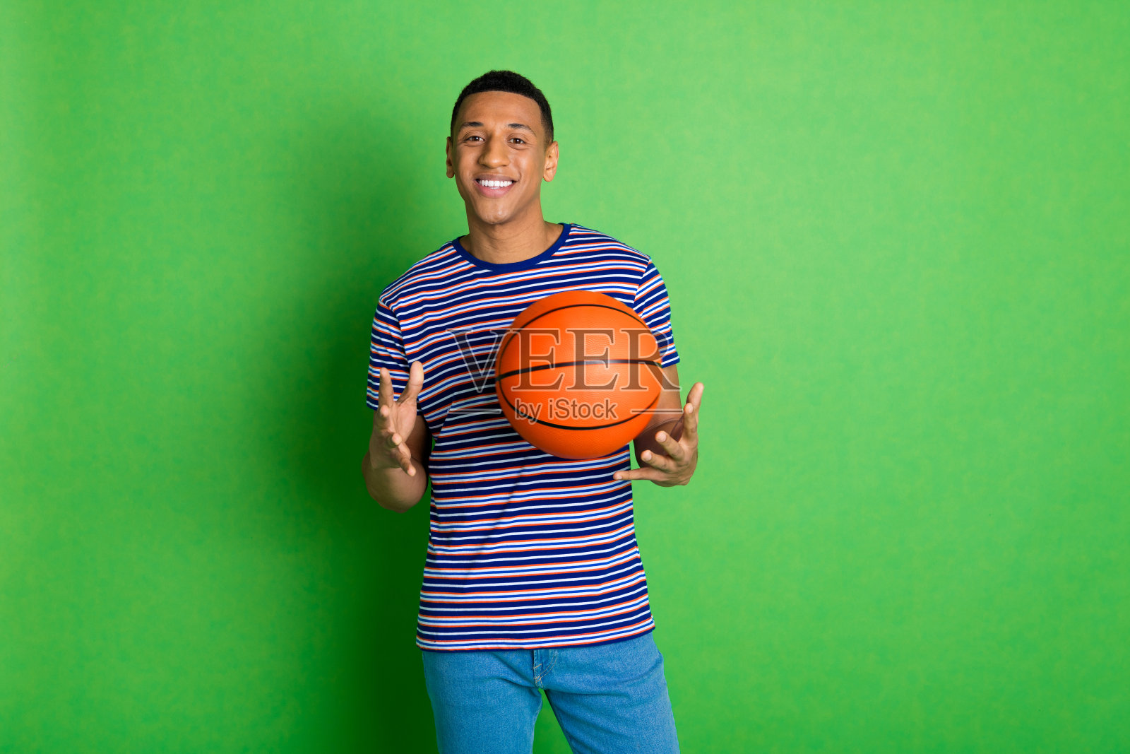 照片的高兴的好积极的男人穿条纹时尚的衣服接球孤立的绿色背景照片摄影图片