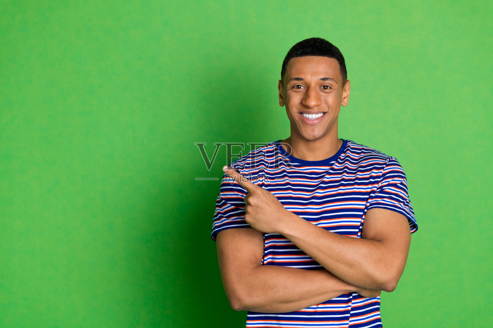 照片正面的好男人穿着条纹时尚的衣服展示空白空间孤立的绿色背景照片摄影图片