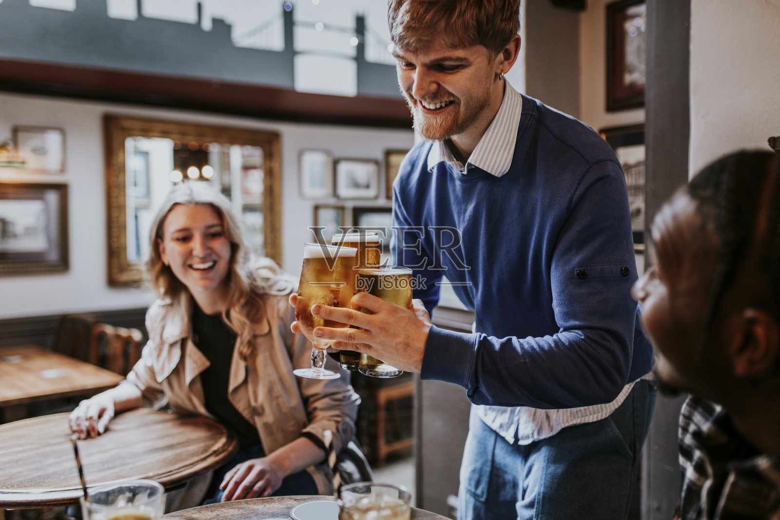 一名男子在酒吧为朋友斟酒照片摄影图片