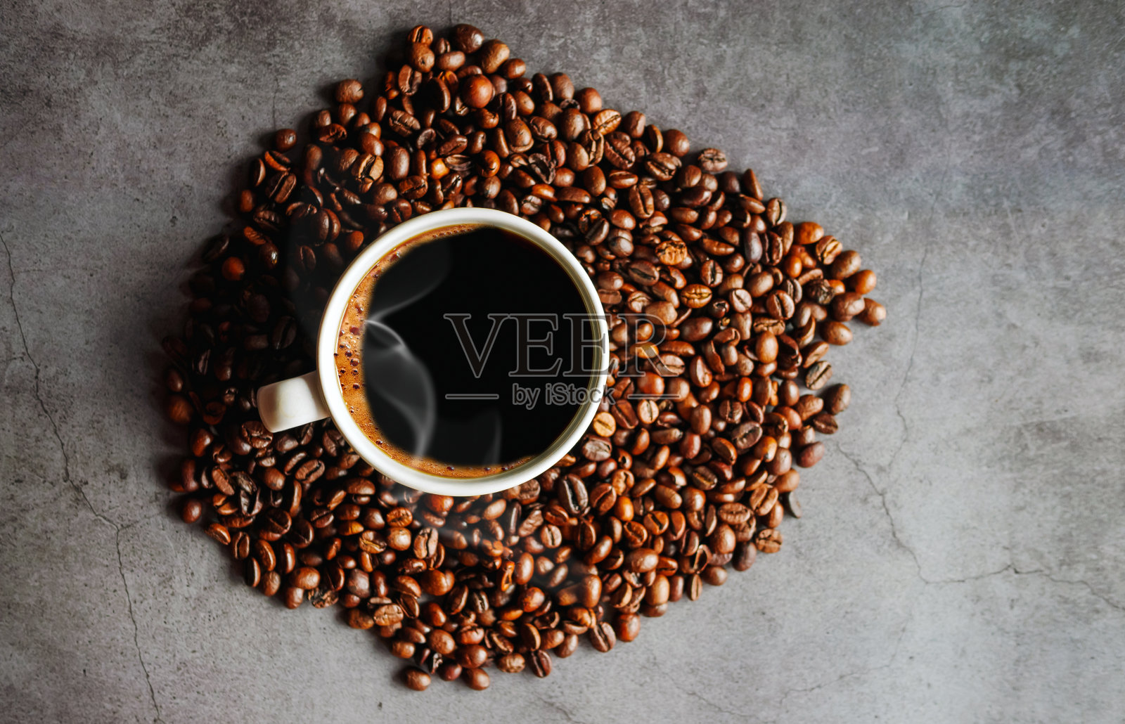 俯视黑咖啡杯的芳香。灰色背景上的咖啡杯和咖啡豆照片摄影图片