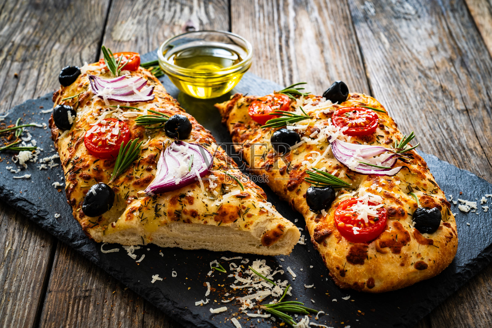 佛卡西亚-烤马苏里拉三明治与火腿，西红柿和芝麻菜黑色石盘照片摄影图片