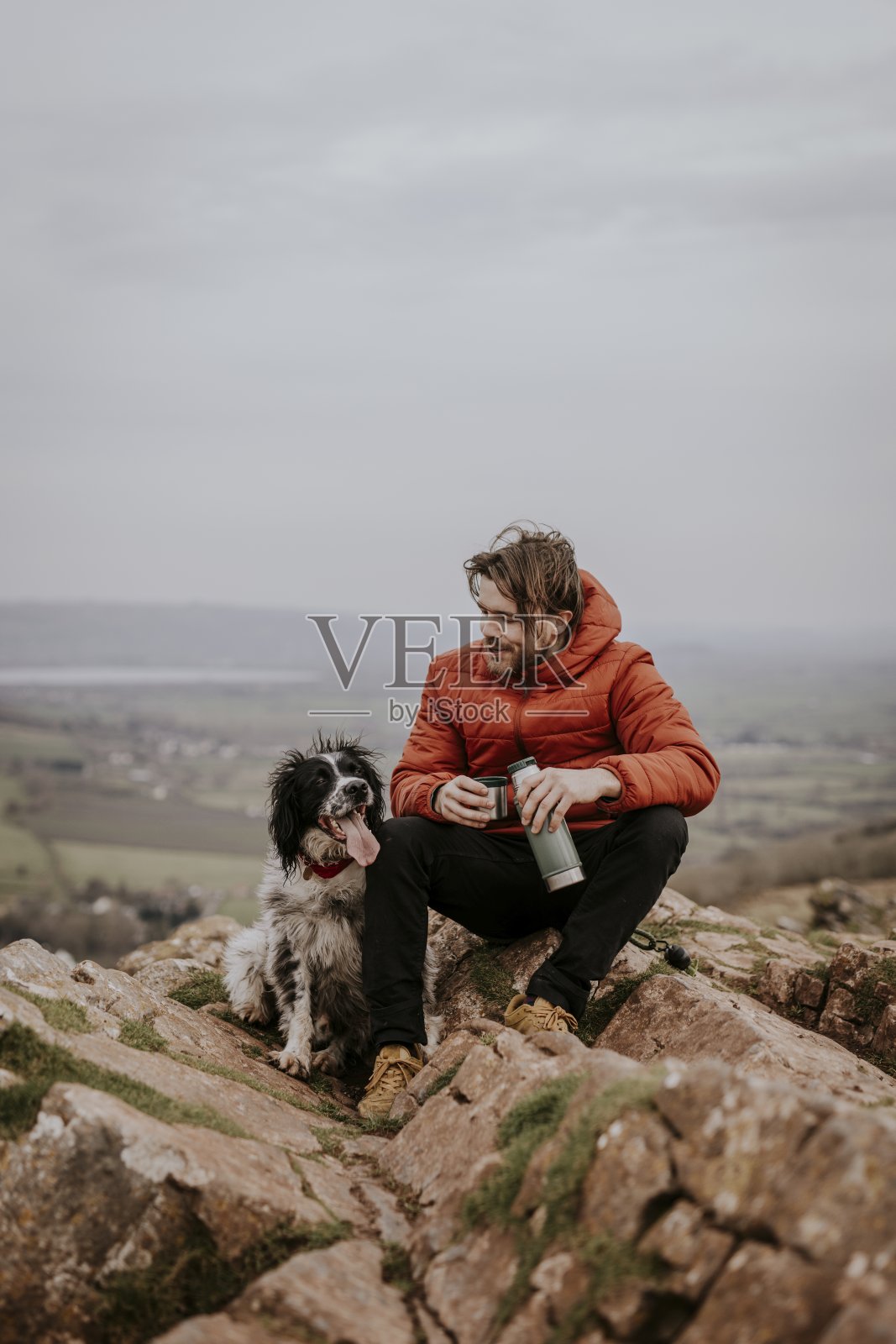 一个男人和他的狗在山上合影照片摄影图片