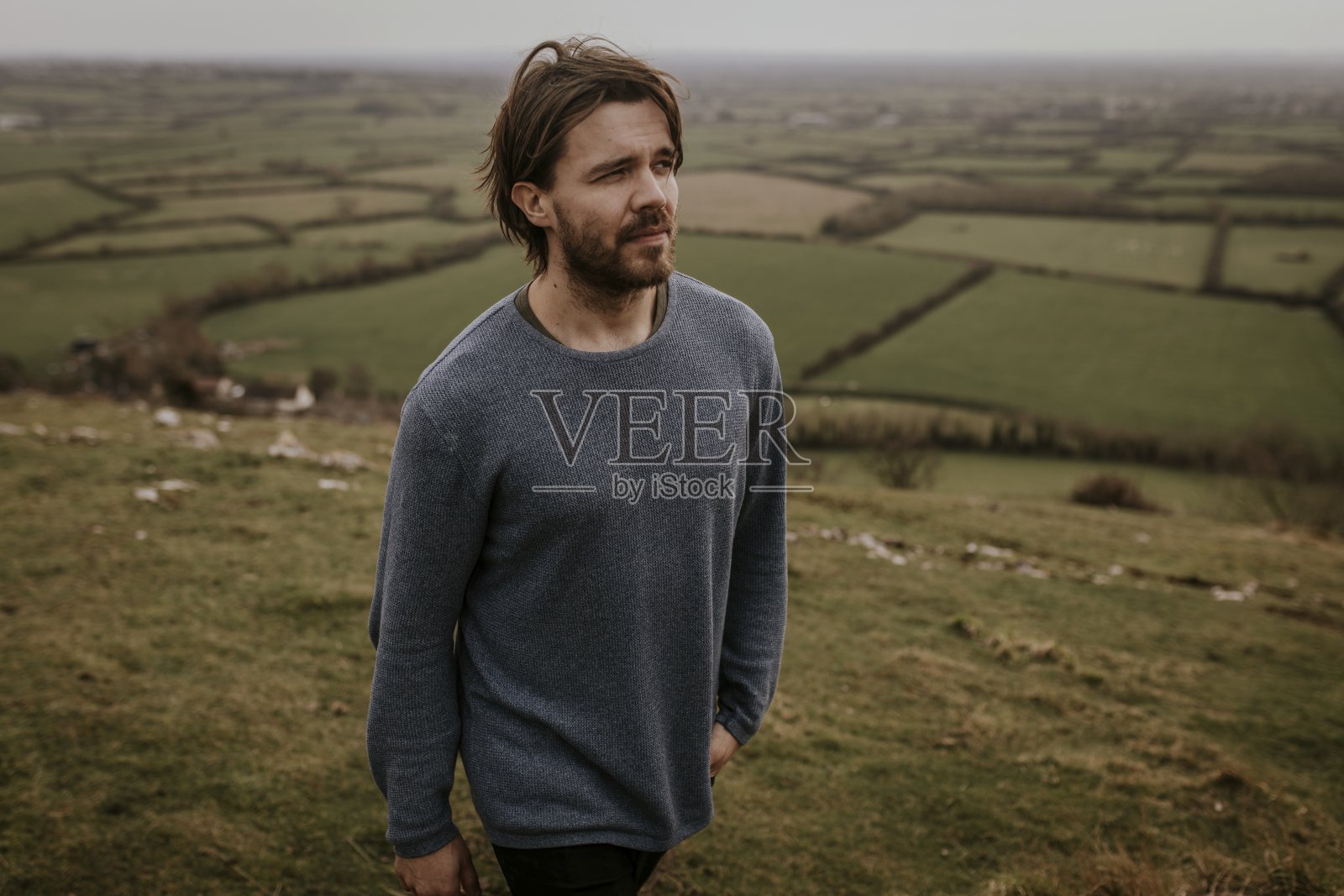 男人穿着长袖衬衫，走在山上照片摄影图片