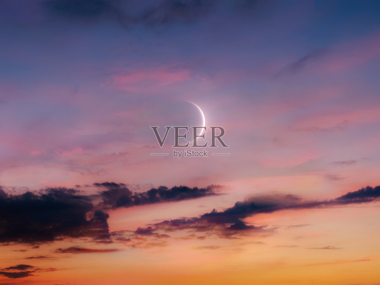 日落时天空中的新月。月亮升起来了。照片摄影图片