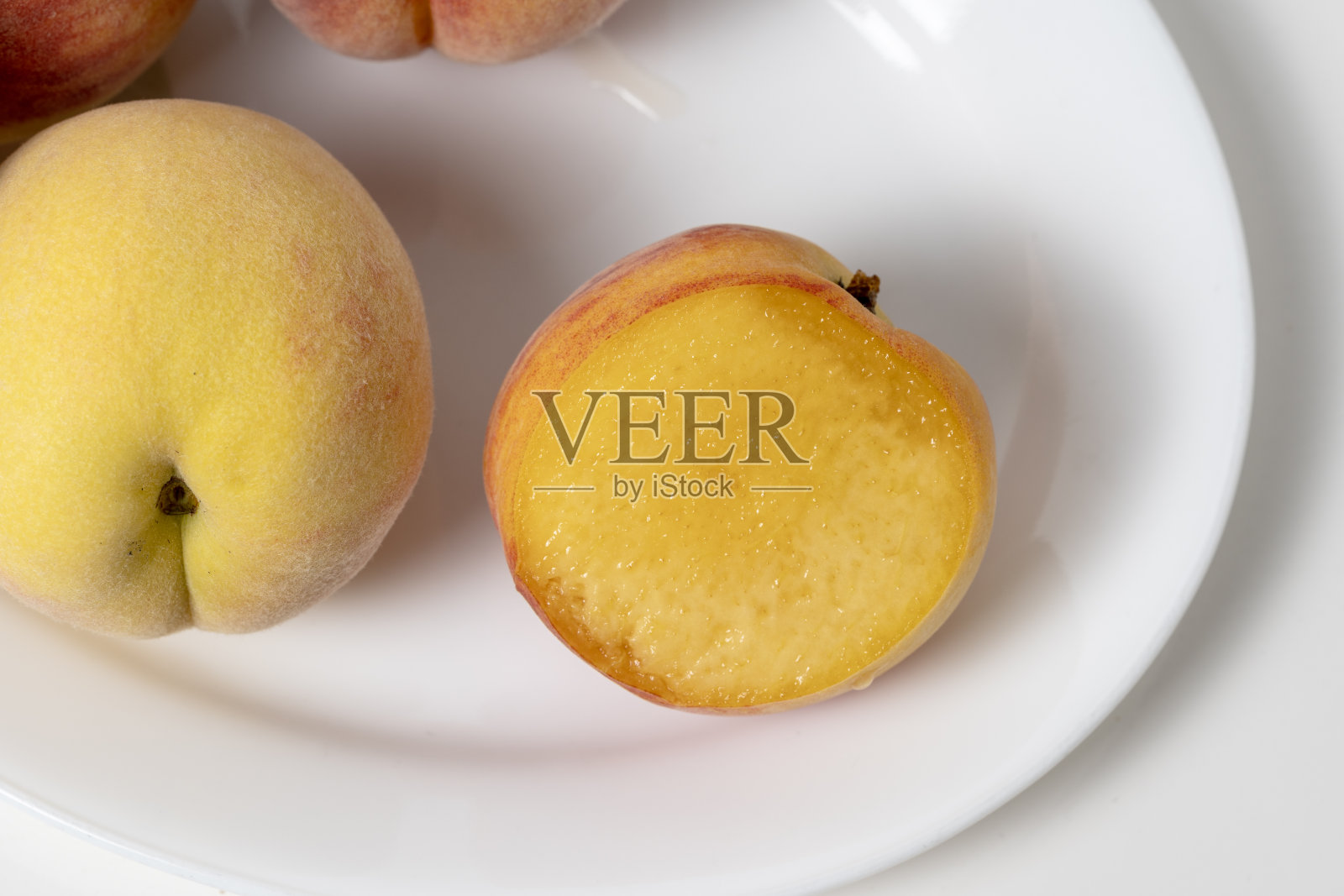 桃子多汁、甜，外皮毛茸茸，里面有一个核。照片摄影图片