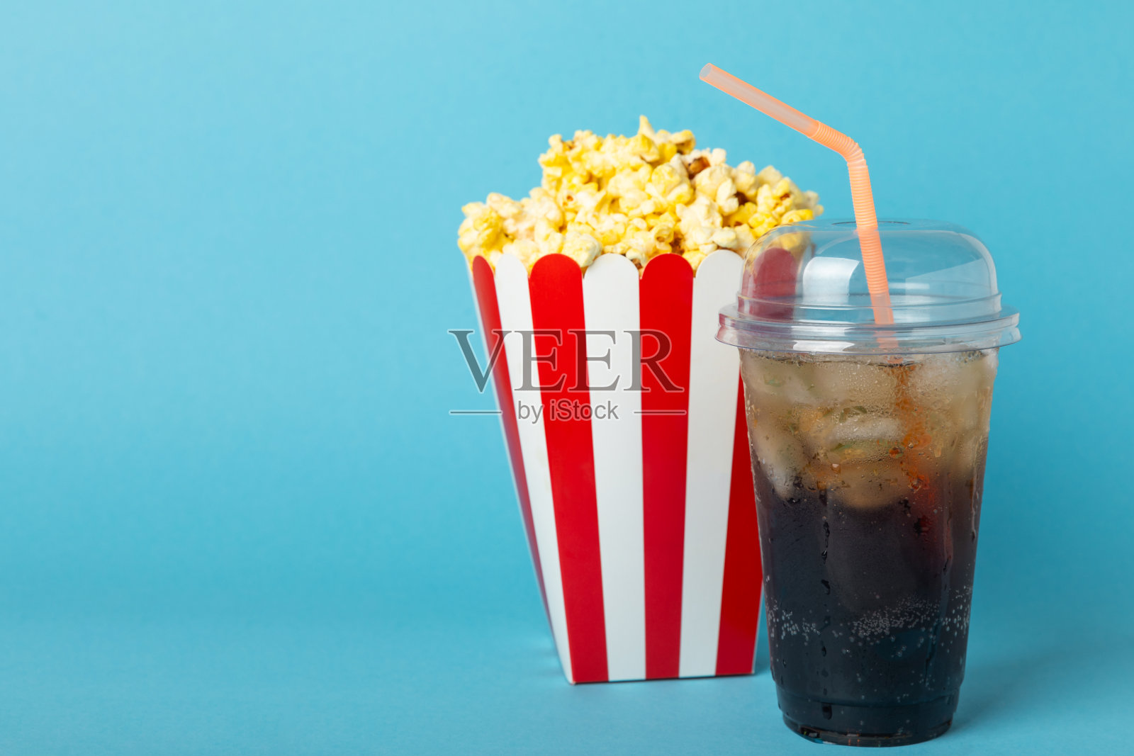 桶里装着美味的爆米花，喝着冰凉的可乐，还有电影票、电影拍板和彩色背景上的3D眼镜。电影的概念。看电影。放文字的地方。本空间照片摄影图片