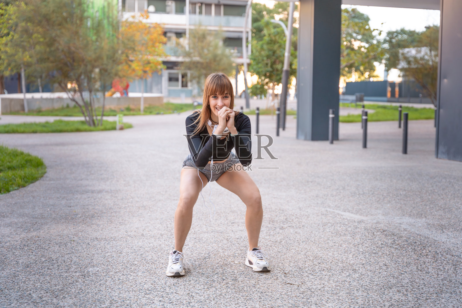 活跃和健康的女运动员在户外做深蹲运动。照片摄影图片
