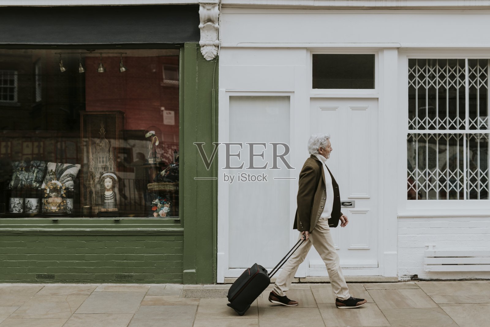 老年游客在街道背景中提着行李照片摄影图片