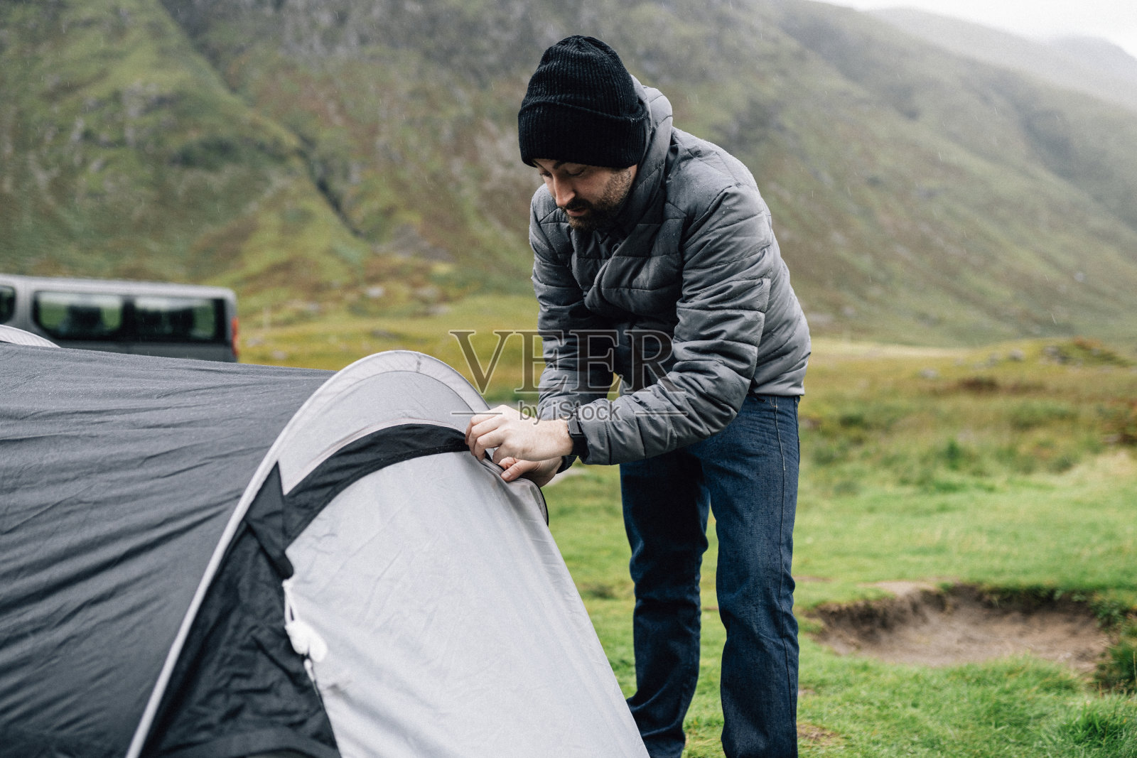 一个人在雨中拉上帐篷的拉链照片摄影图片