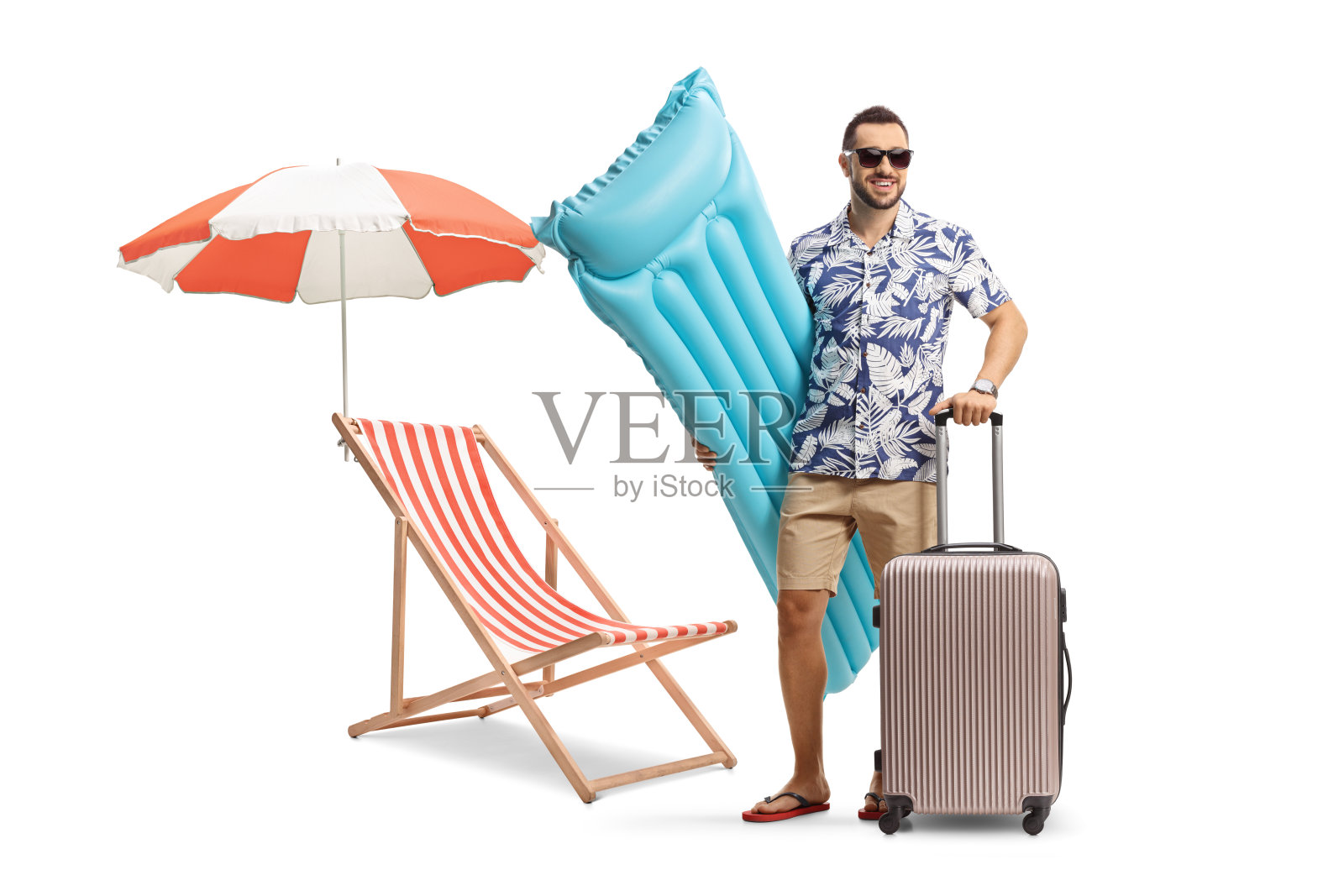一名男子手持充气床垫和手提箱，坐在沙滩椅旁照片摄影图片