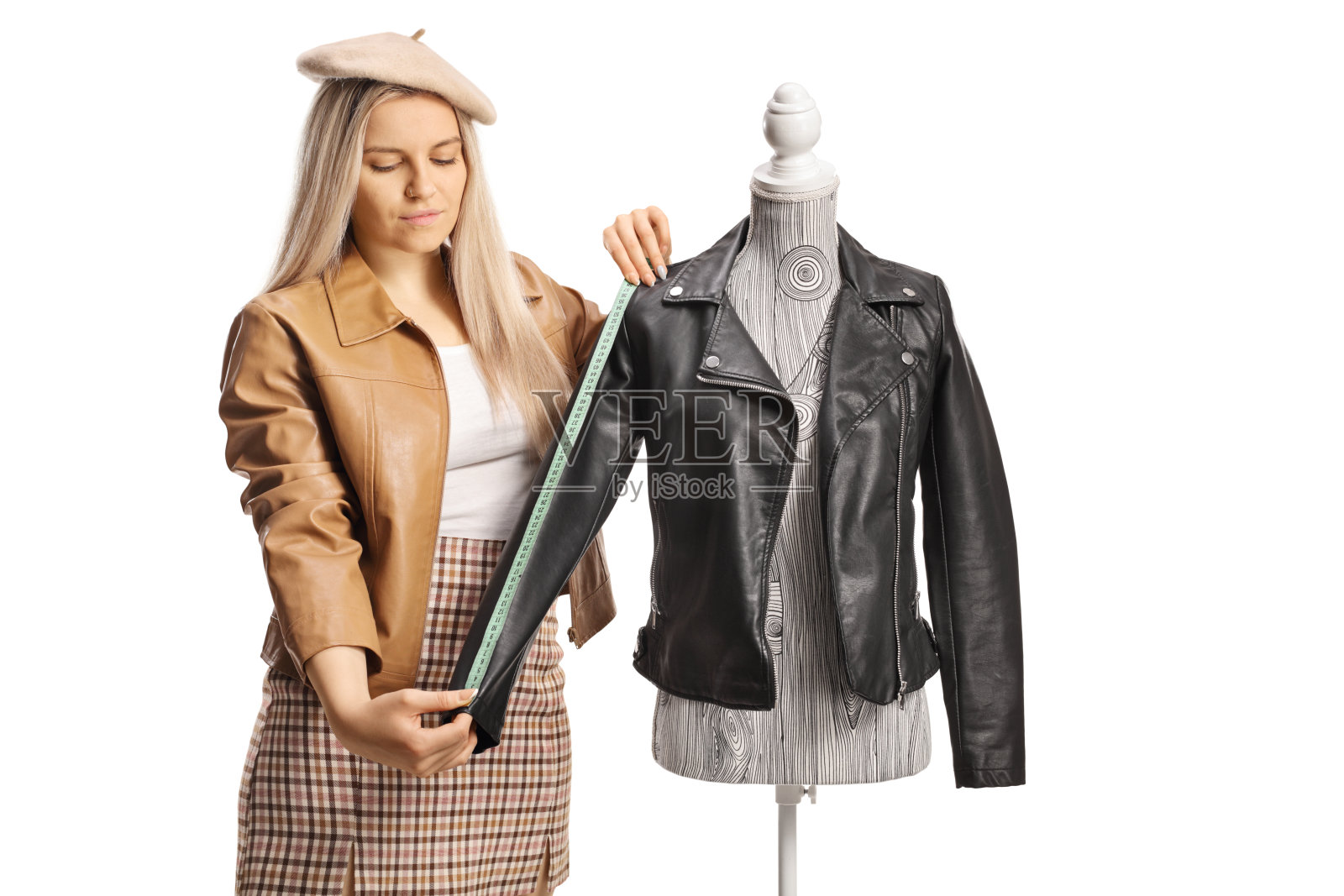 年轻的女时装设计师在人体模型娃娃上测量夹克袖子照片摄影图片