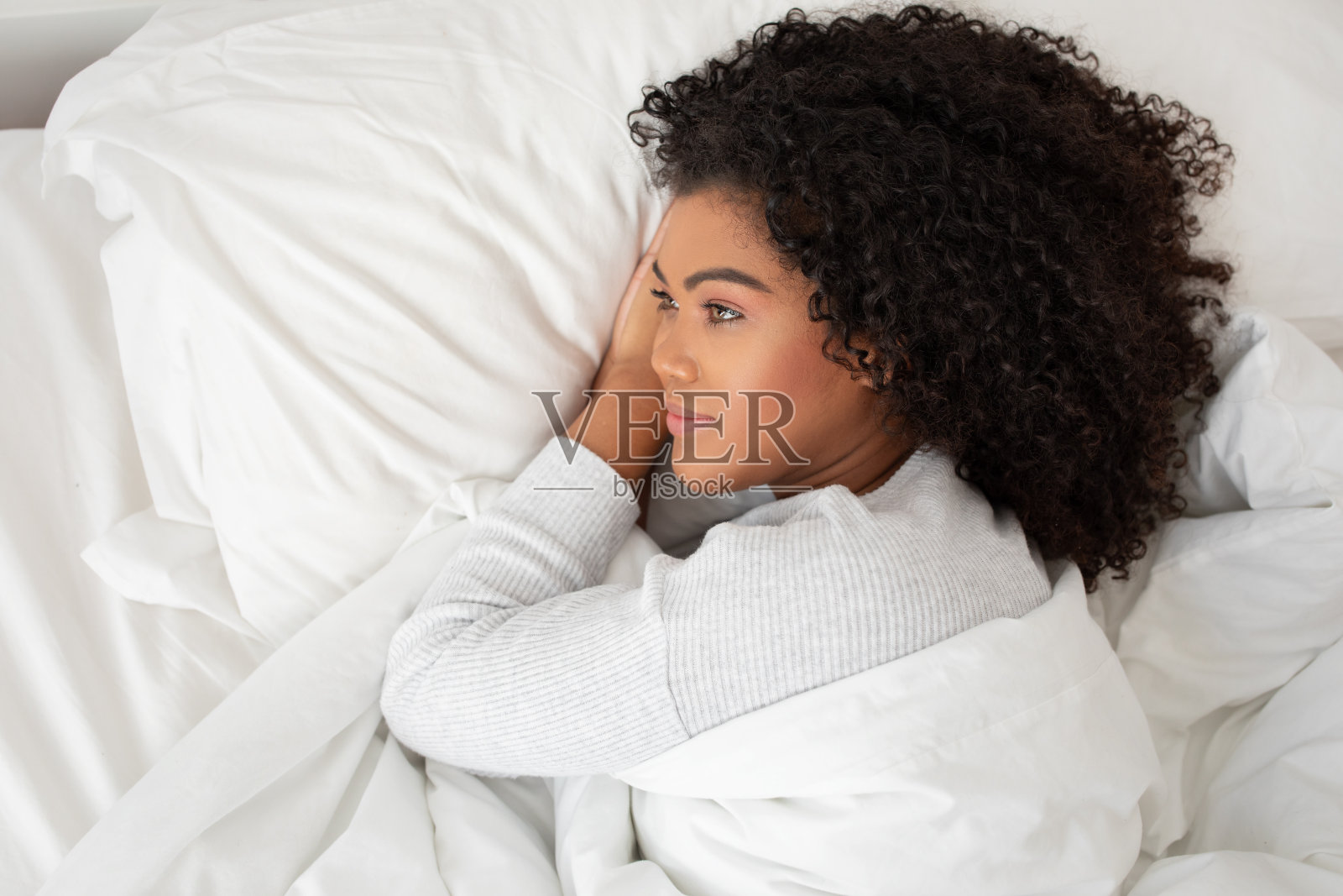 躺在床上的女人盖着白毯子照片摄影图片