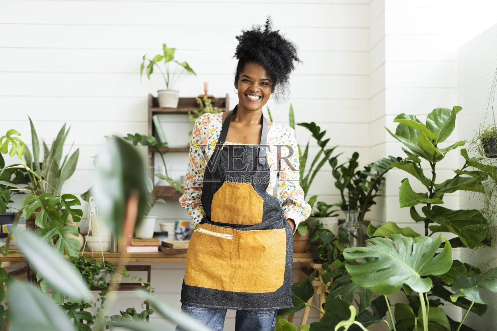 快乐的小企业主在一个植物店照片摄影图片