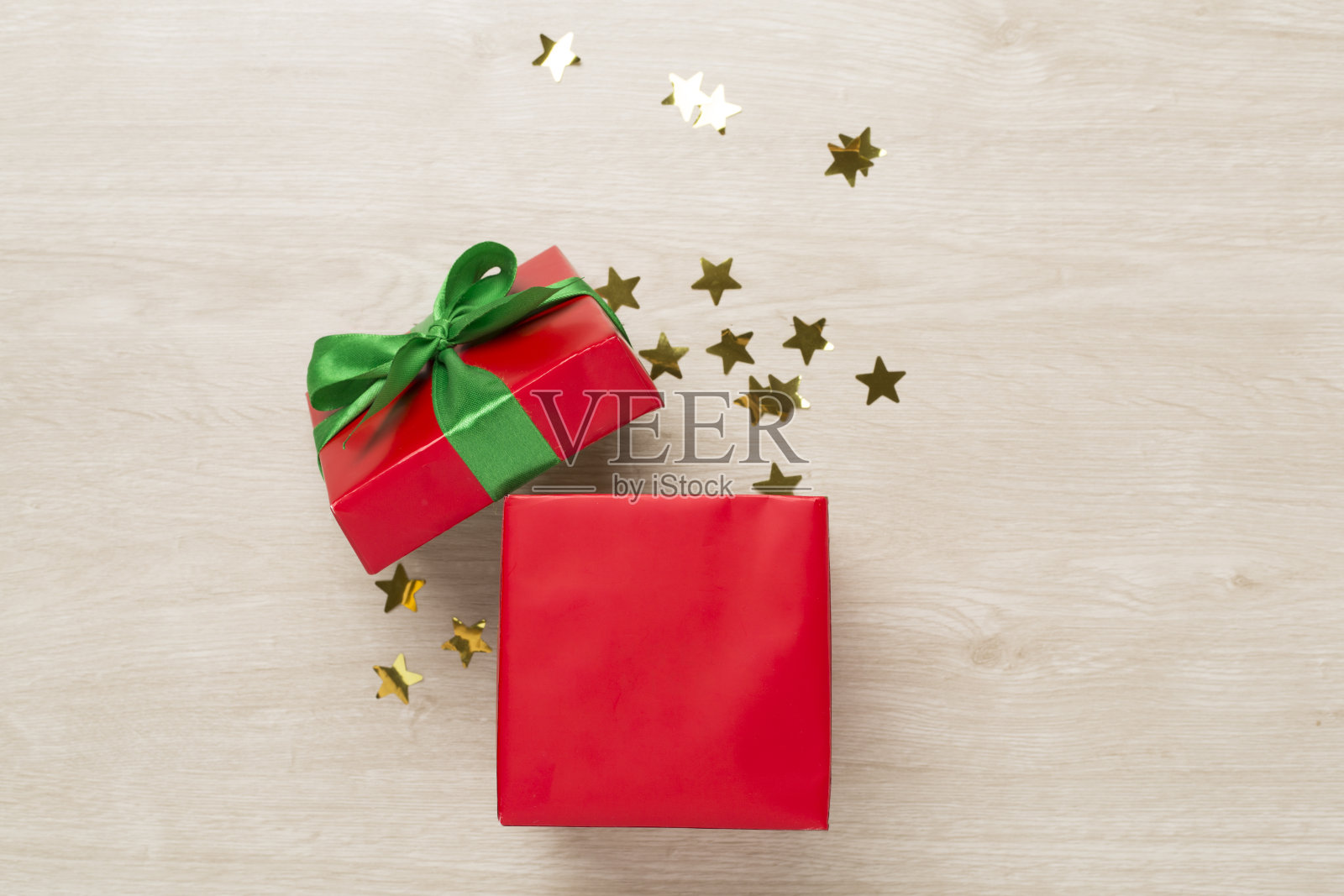 打开红色礼盒，木质背景上有派对彩纸，俯视图照片摄影图片