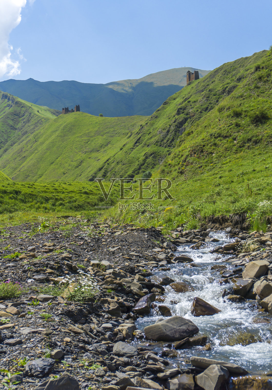 急流峡谷中石河床中的山河急流基斯塔堡垒的废墟和山顶上长满绿草的塔楼照片摄影图片