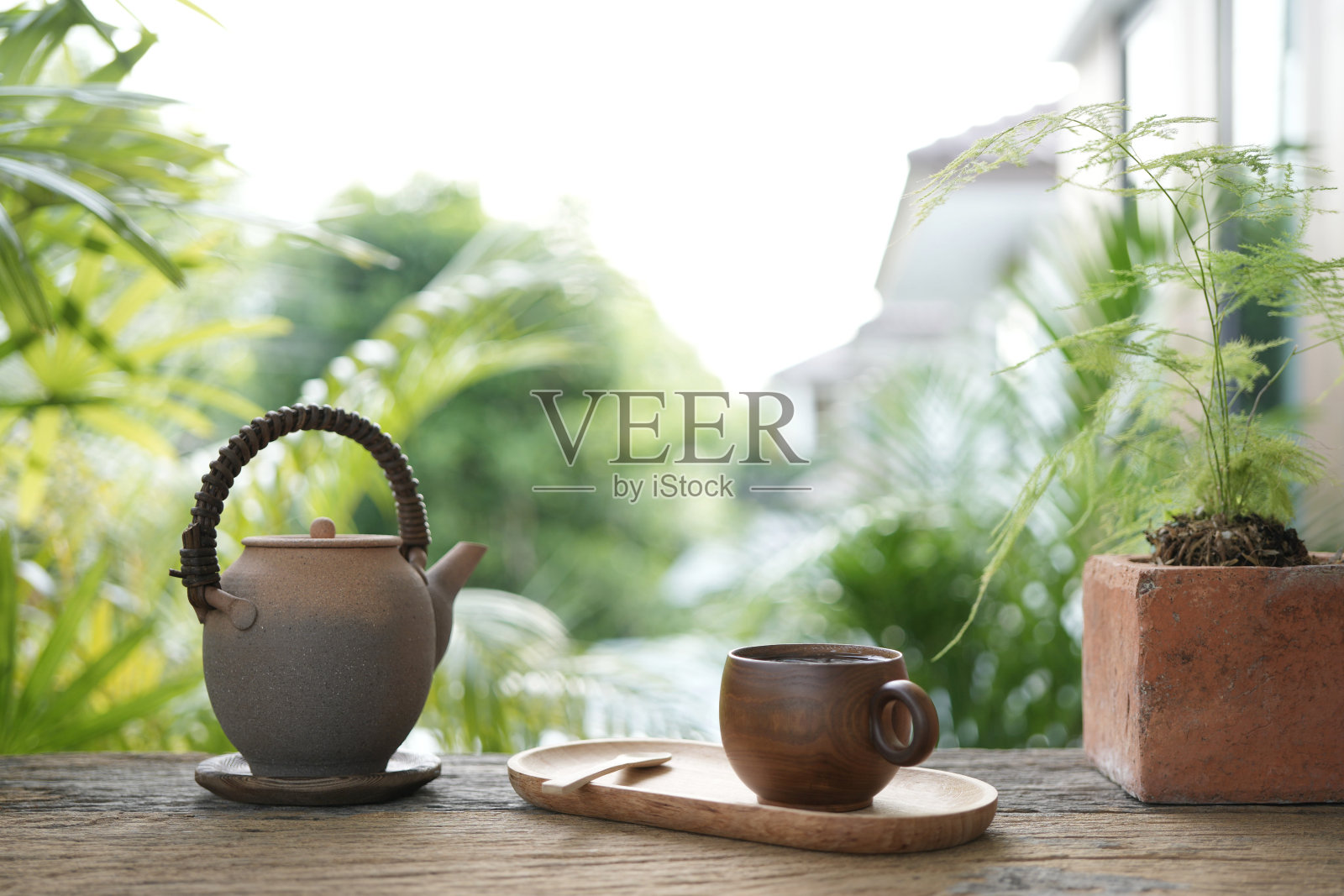 阳台上的棕色木制茶杯和陶制茶壶让人心旷神怡照片摄影图片