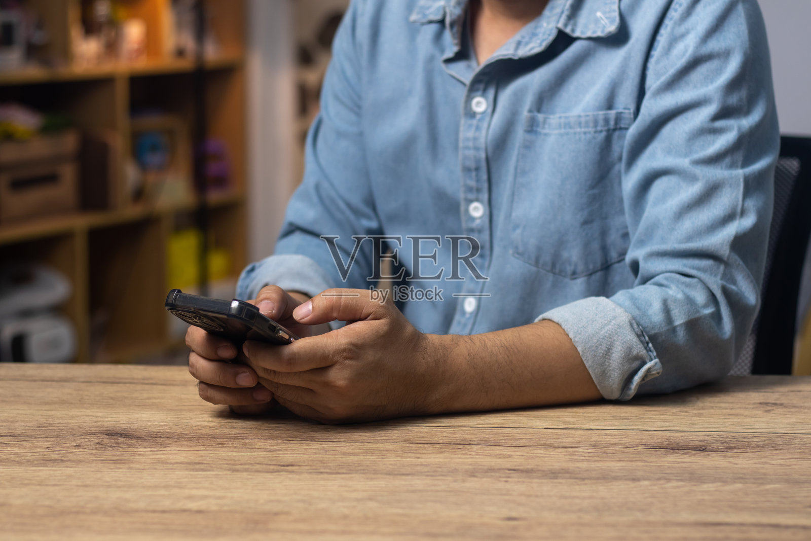 男人的手放在桌子上使用手机、科技、通讯、互联网。照片摄影图片