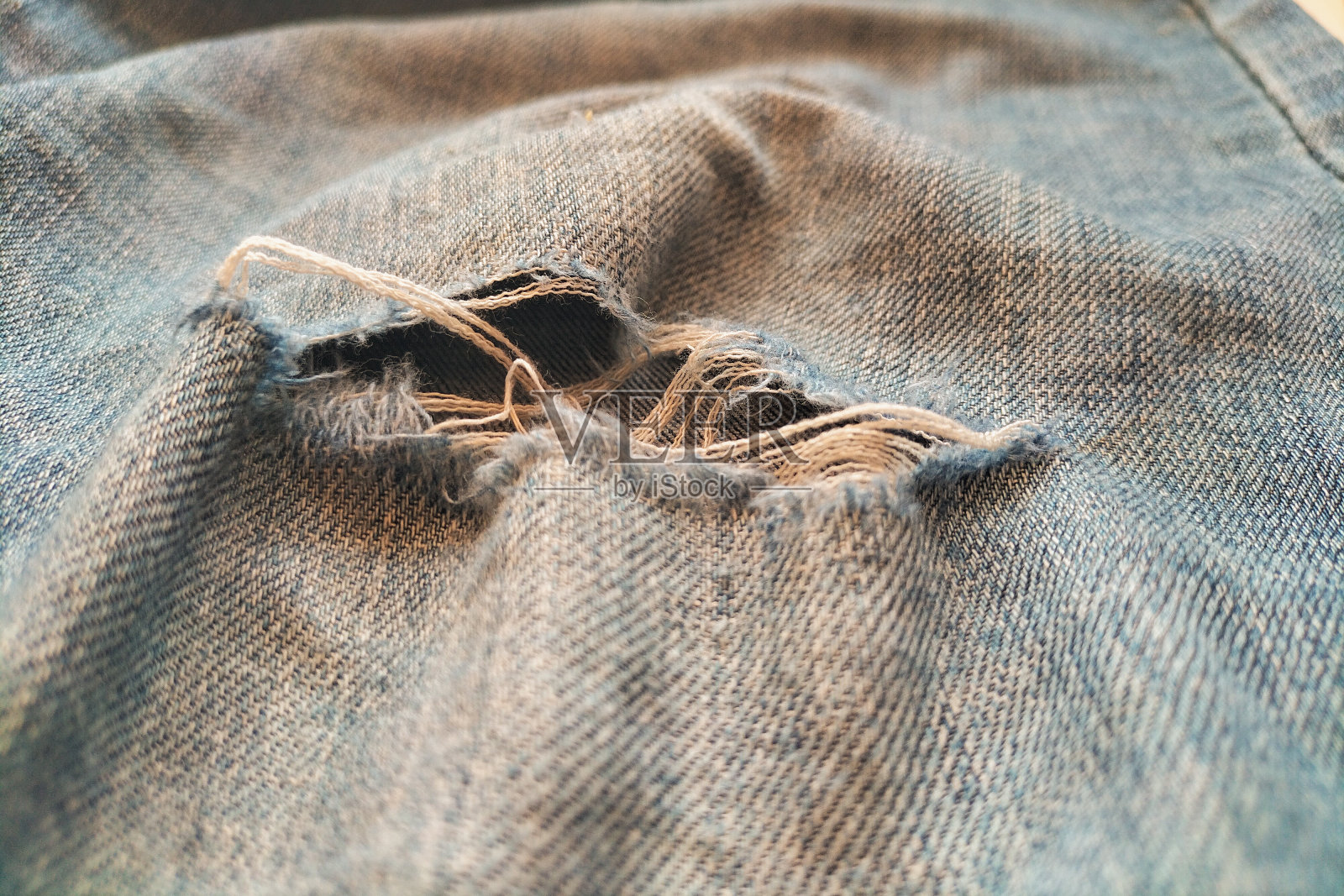 衣服上有撕裂的部分，磨损的东西，设计师潮流的时尚，败类和无家可归的风格。照片摄影图片