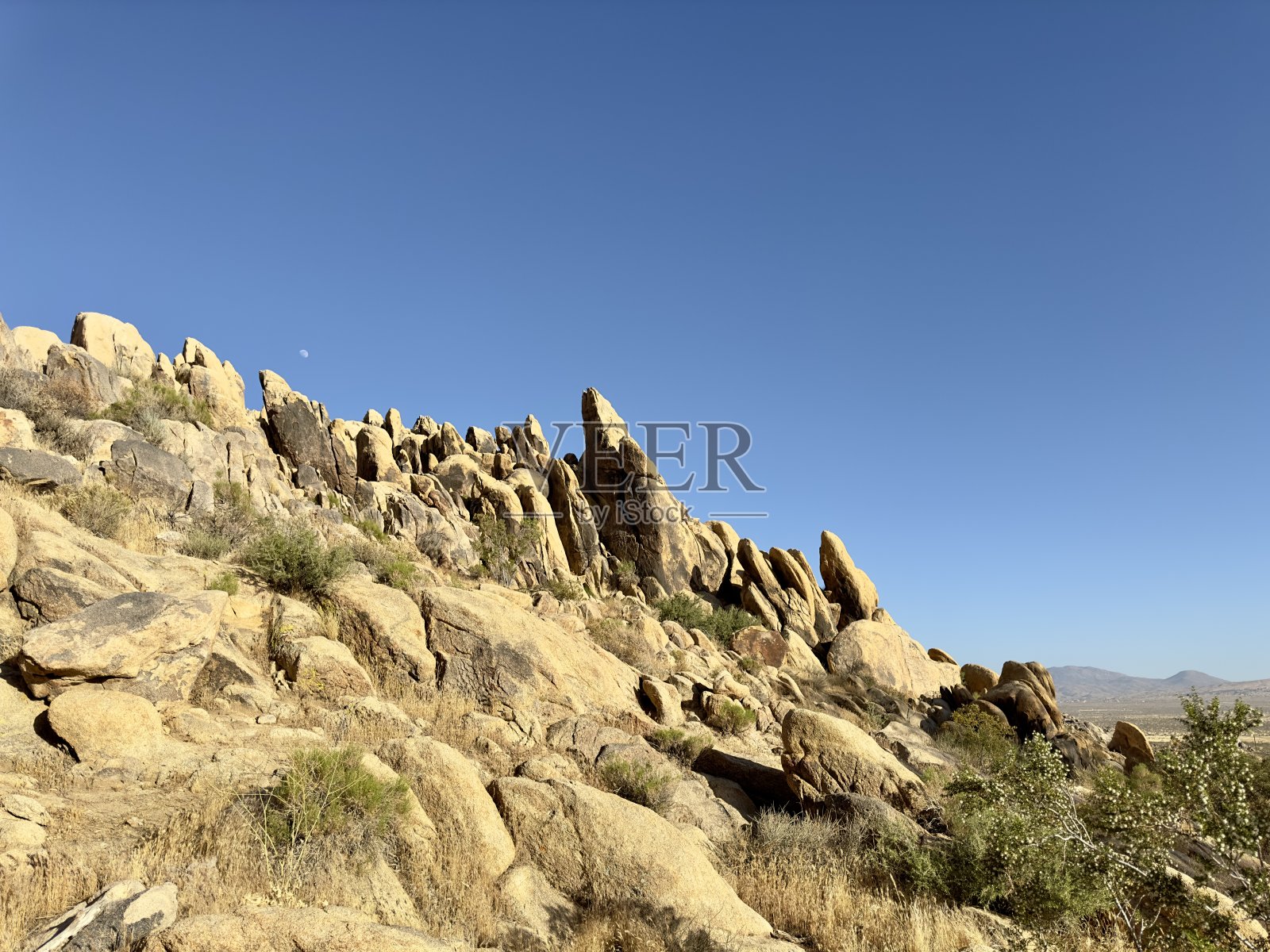 巨大的巨石和岩石占据了崎岖的山地沙漠景观，在干旱地形的背景下，创造了一个戏剧性的、鲜明的自然美景、弹性和永恒的场景。照片摄影图片