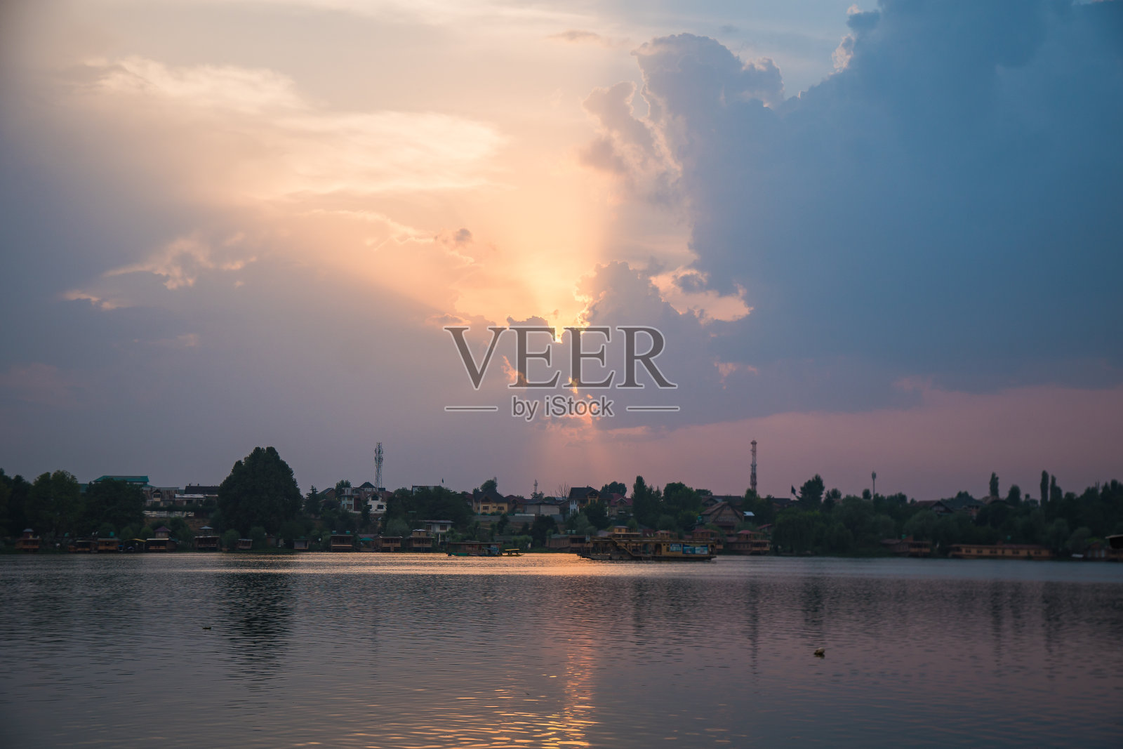 日落时分，一对夫妇在印度克什米尔斯利那加的达尔湖上平静地划船照片摄影图片