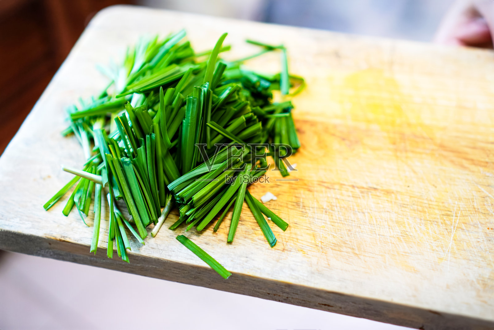 韭菜在砧板上切成小块，用作烹饪原料的照片。照片摄影图片