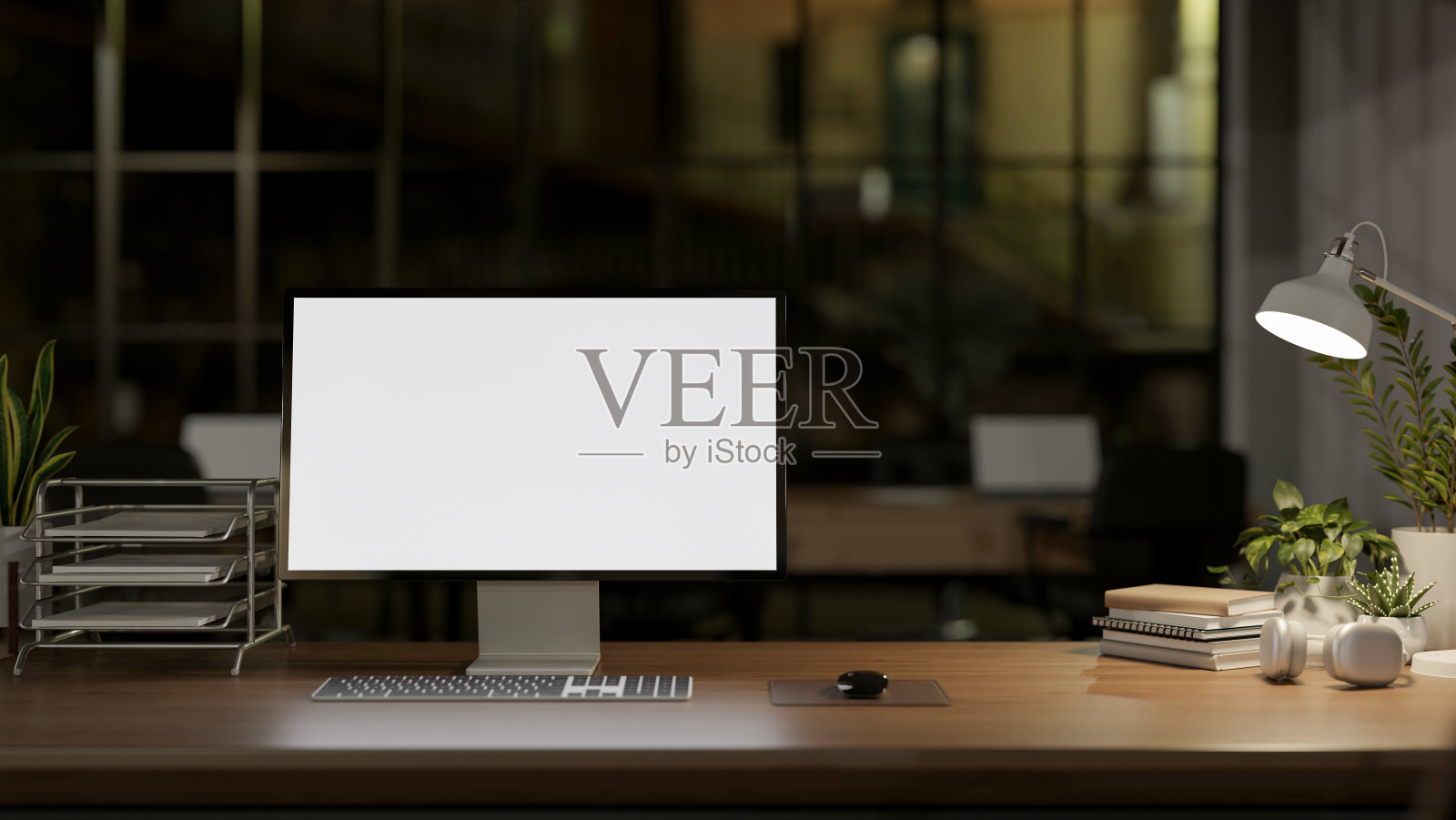 夜间的现代办公室以PC电脑模型和台灯的昏暗灯光为特色。照片摄影图片