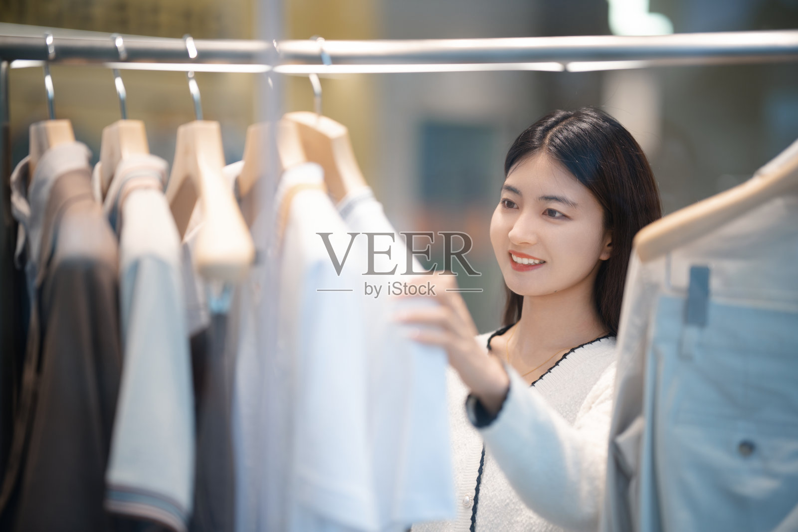 年轻漂亮的女人在服装店买衣服照片摄影图片