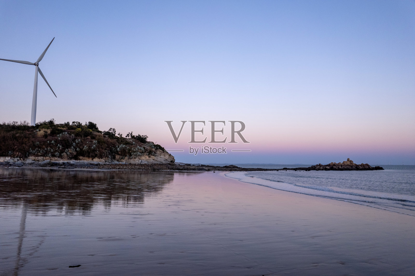 黄昏时的海滩、海浪和风车照片摄影图片