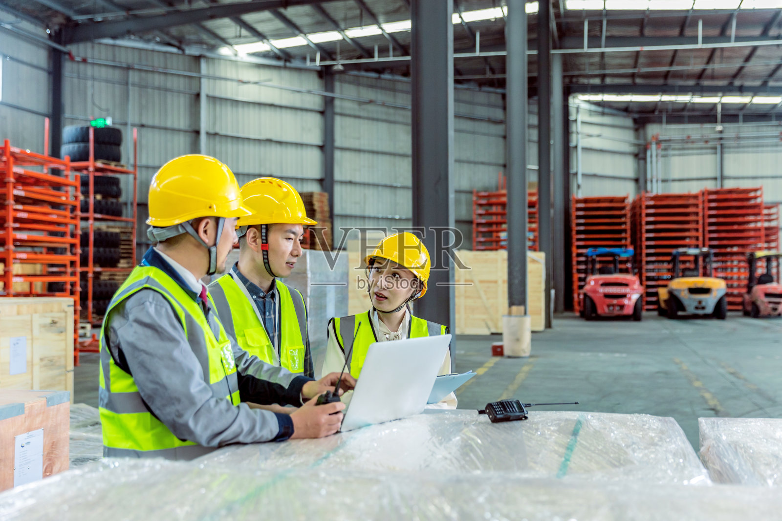 三个亚洲工人在仓库使用笔记本电脑和讨论照片摄影图片