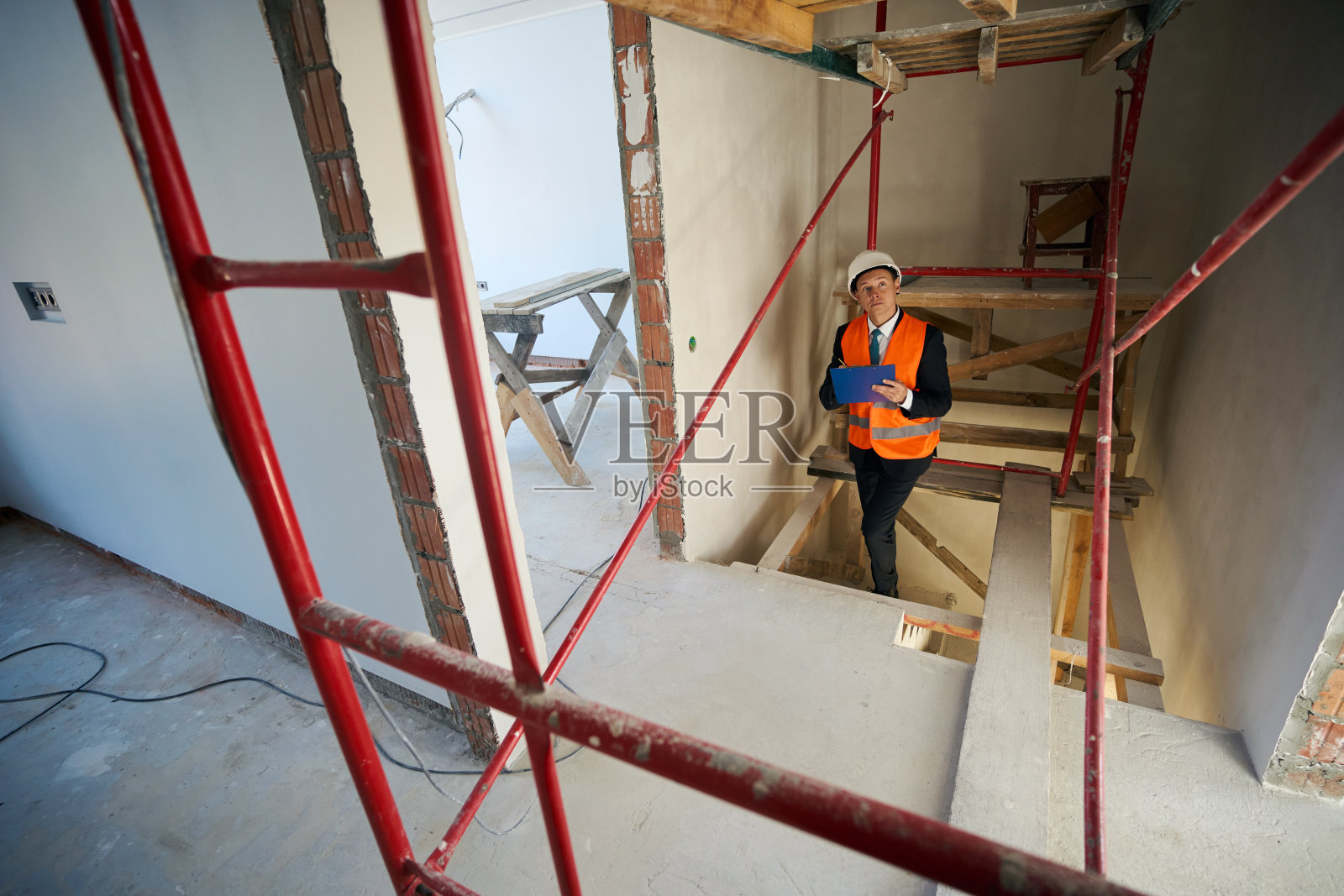 建筑工头在爬楼梯时在剪贴板上写字照片摄影图片