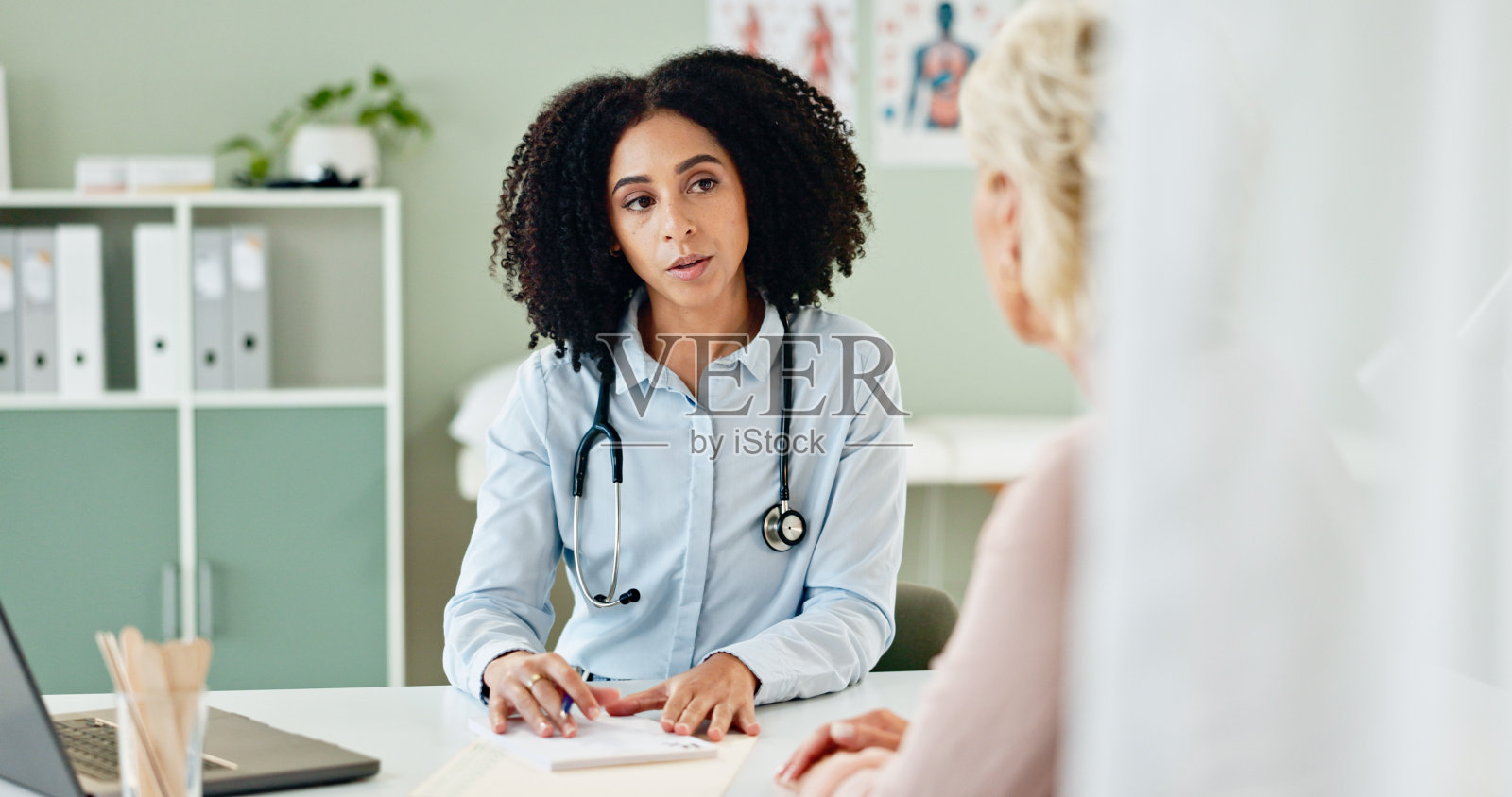 医生、妇女或患者在咨询有关保健支助、医疗结果或反馈的文书工作。为诊断、报告或保健服务提供处方的药品、专家或人员照片摄影图片