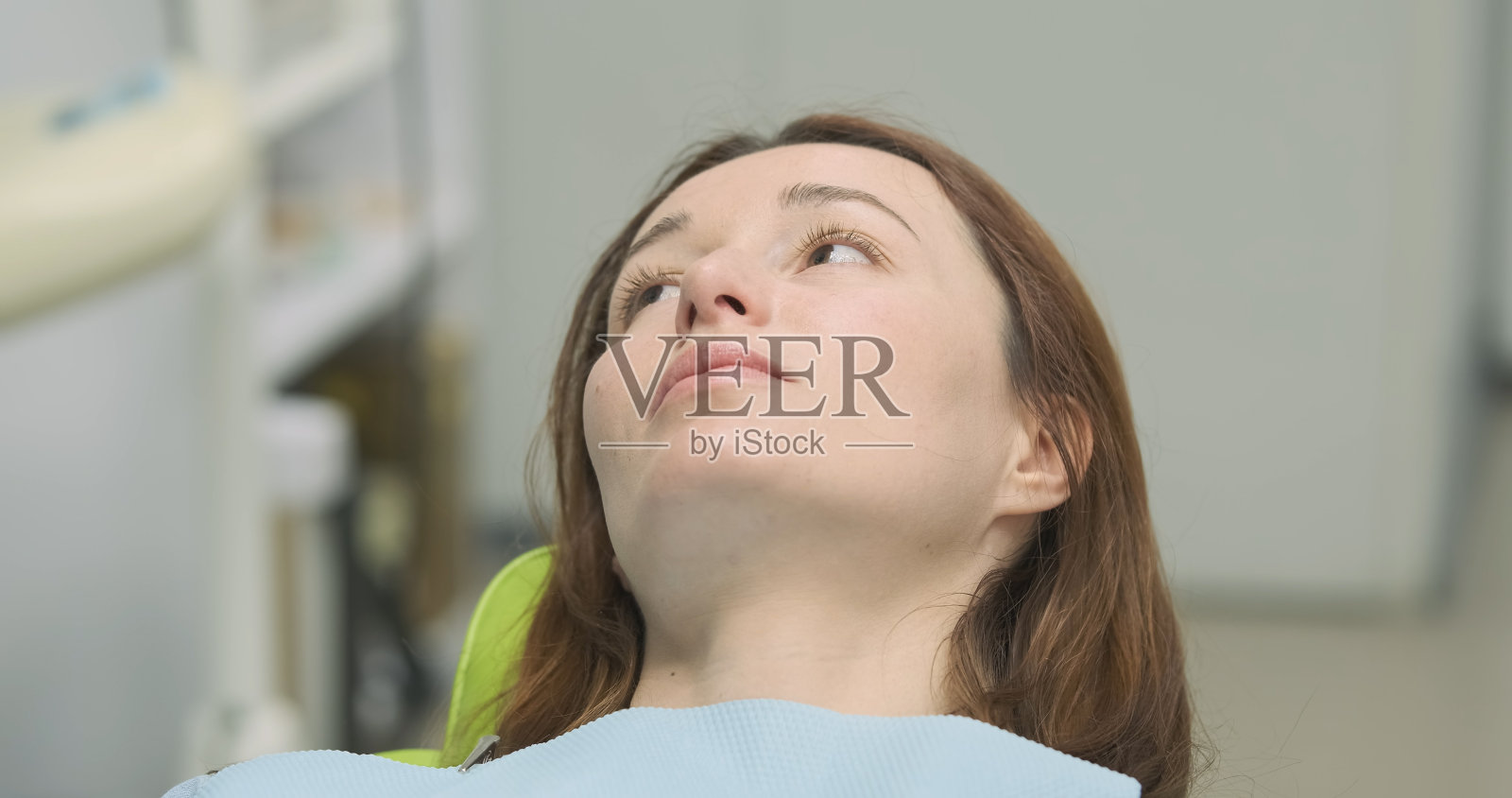 女人躺在牙科椅上，特写照片摄影图片